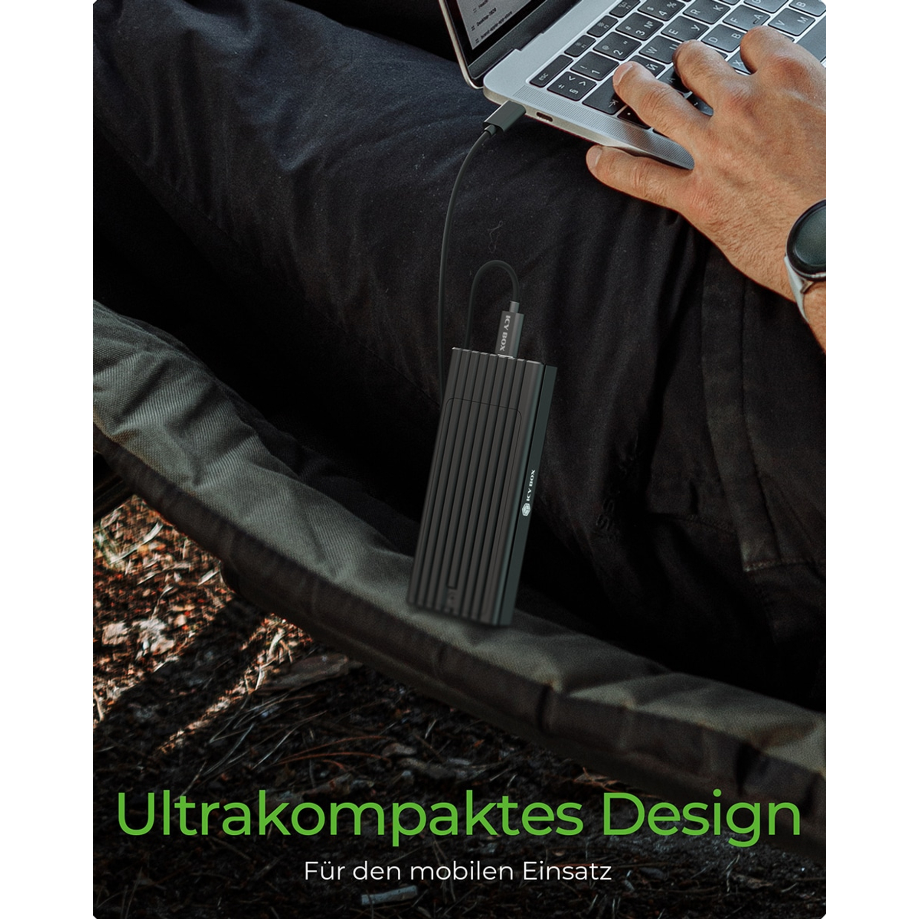 Una persona con un laptop e un disco rigido esterno nero collegato tramite cavo USB.