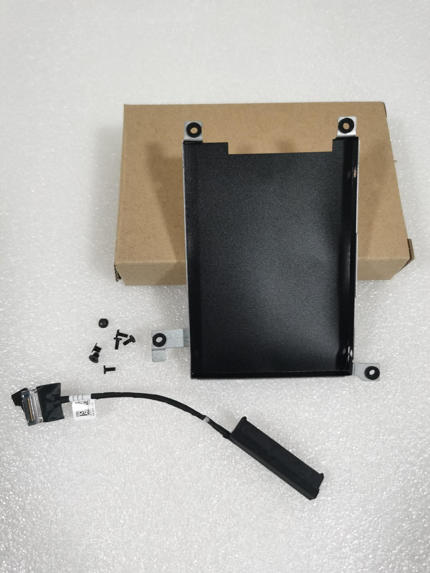 Componenti del disco rigido del laptop, tra cui staffa, viti e un cavo.