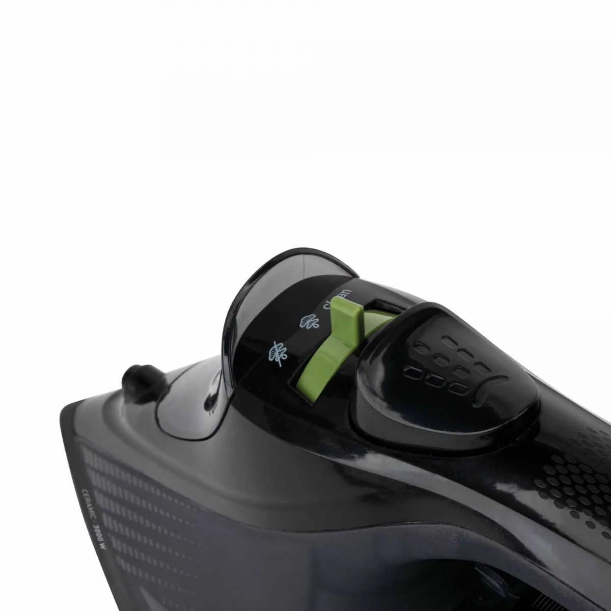 Zbliżenie czarnego żelazka z zieloną tarczą na białym tle.