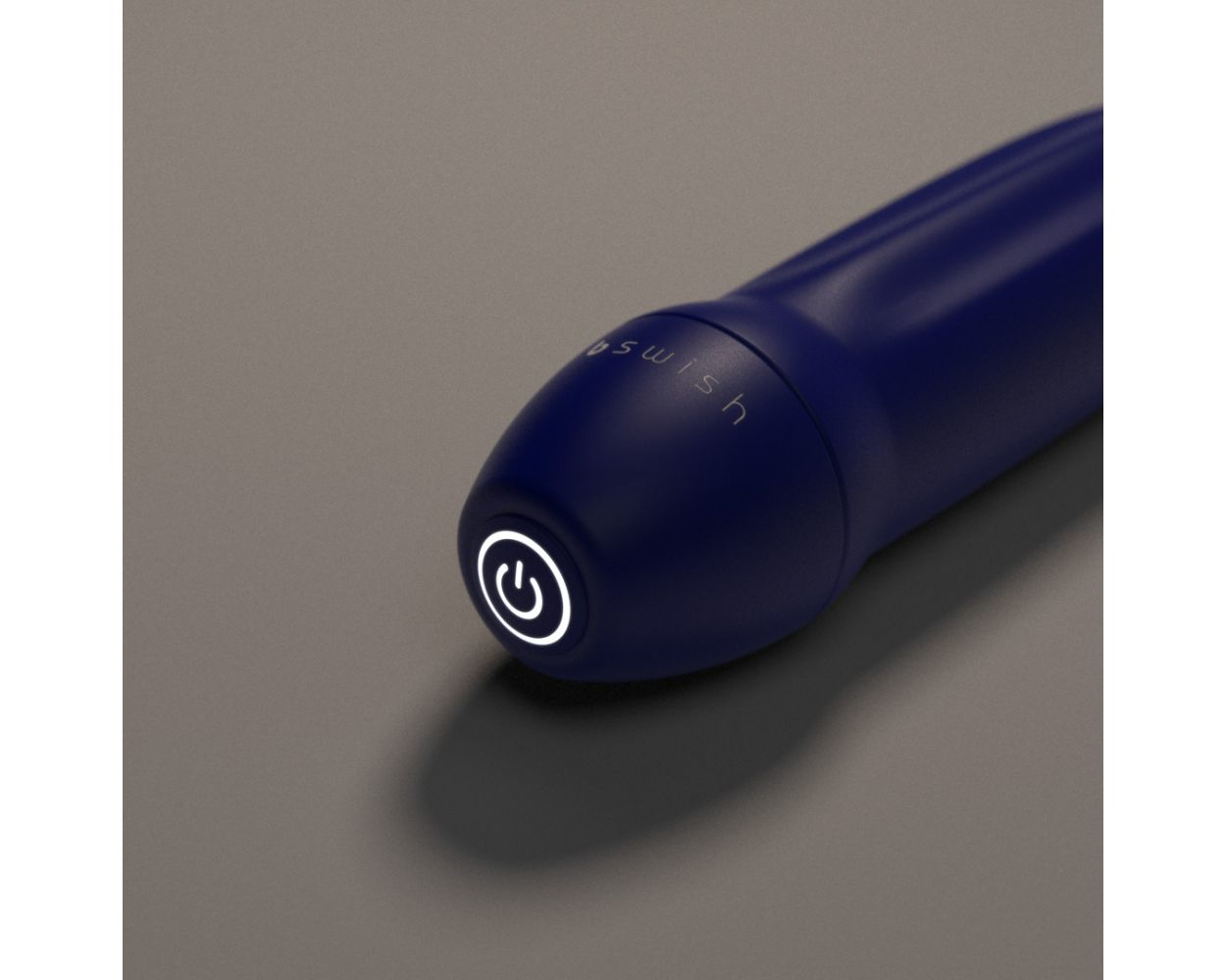 Primer plano de la punta de un vibrador azul con botón de encendido y la palabra 'swish'.