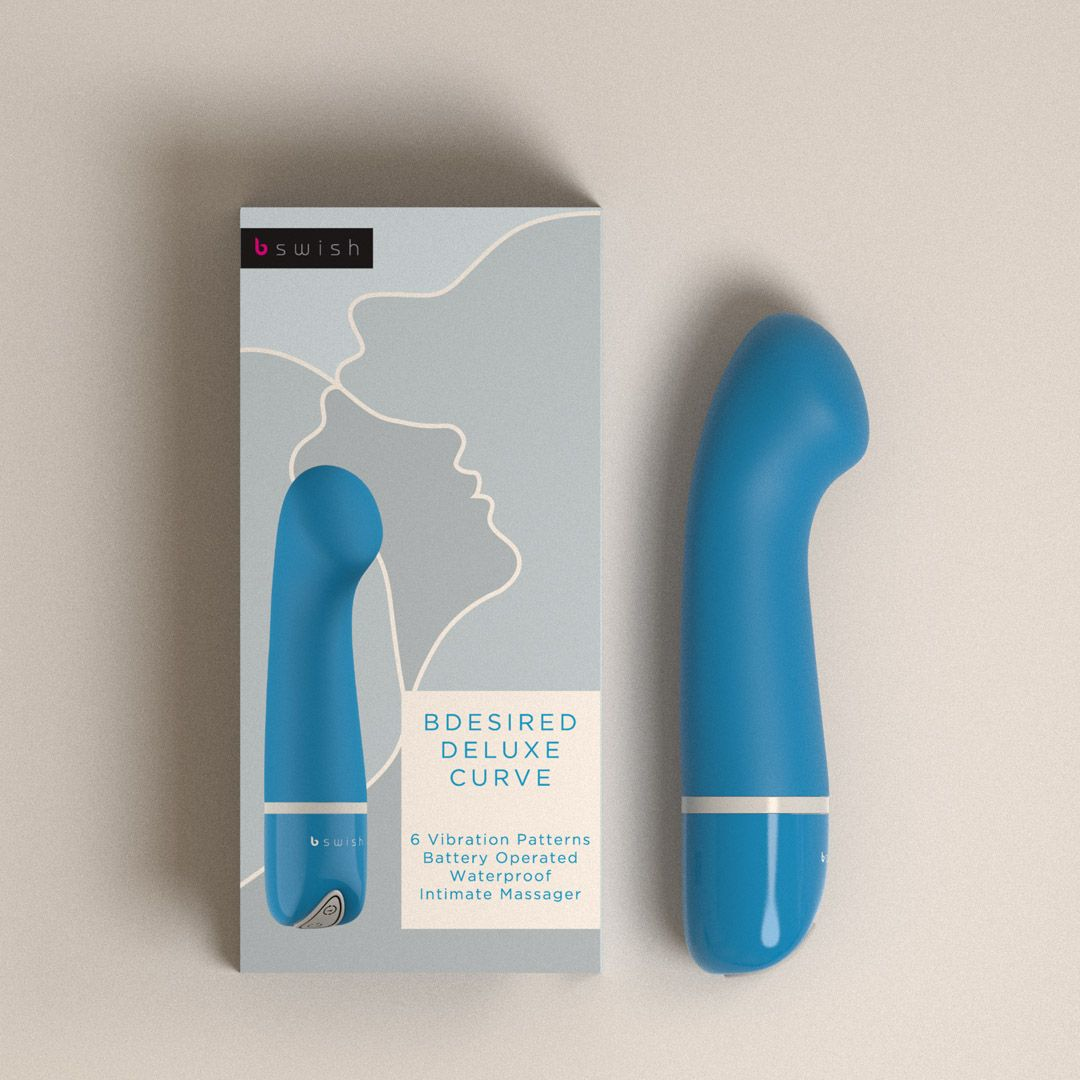 Un vibrador azul con embalaje sobre un fondo beige.