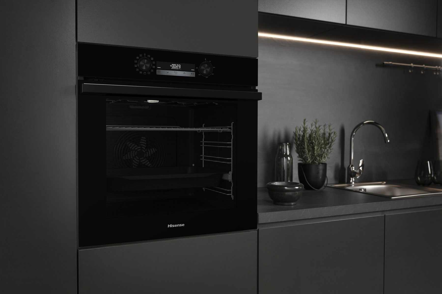 Forno Hisense nero in un ambiente cucina moderno. Il forno è chiuso e la scena è debolmente illuminata.