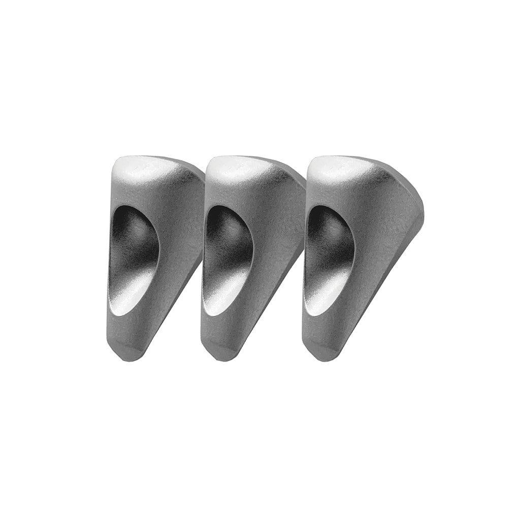 Tre dispositivi di protezione per l'arrampicata in metallo argentato su sfondo bianco. Ognuno ha un buco al centro.