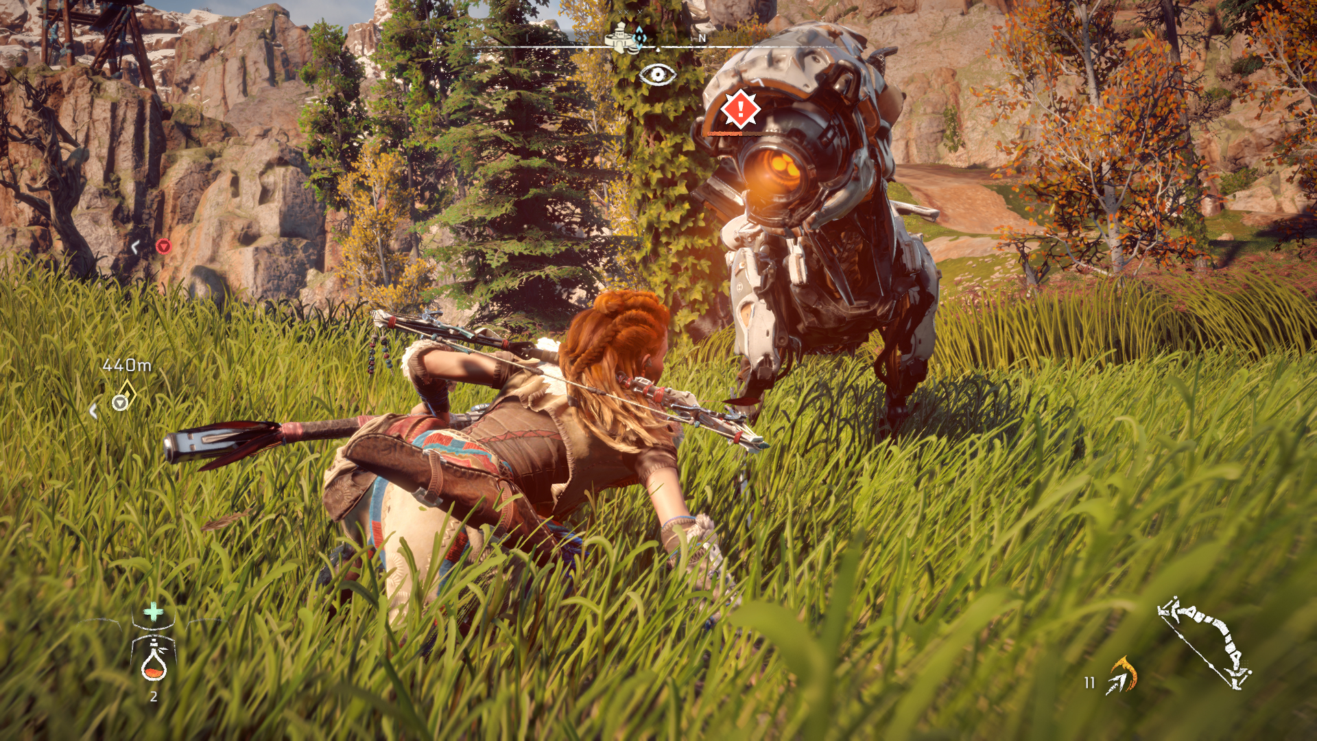 Kobieta w stroju plemiennym celuje z łuku w robota-dinozaura na trawiastym polu, Horizon: Zero Dawn.