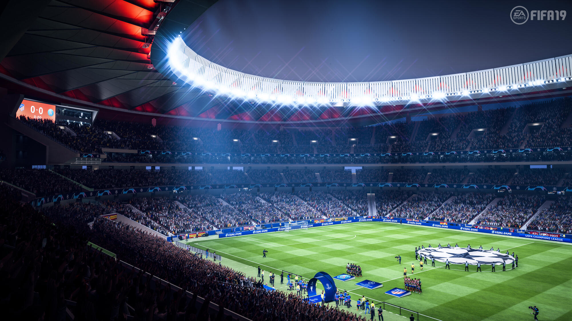 Ein Fußballstadion voller Menschen, die ein Spiel verfolgen. Spielfeld und Anzeigetafel sichtbar.