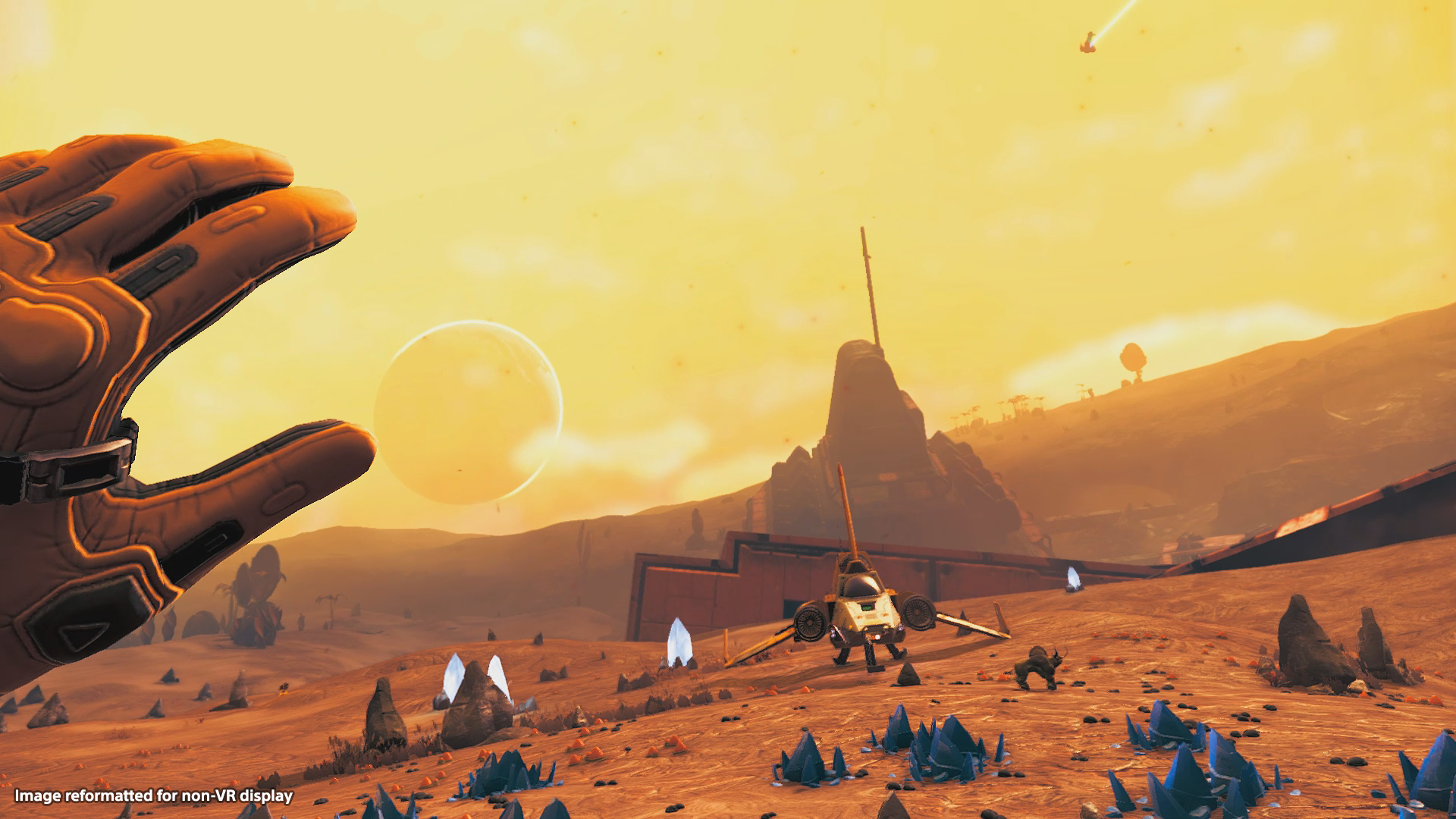 La mano di una persona con un guanto, un paesaggio giallo e un'astronave.