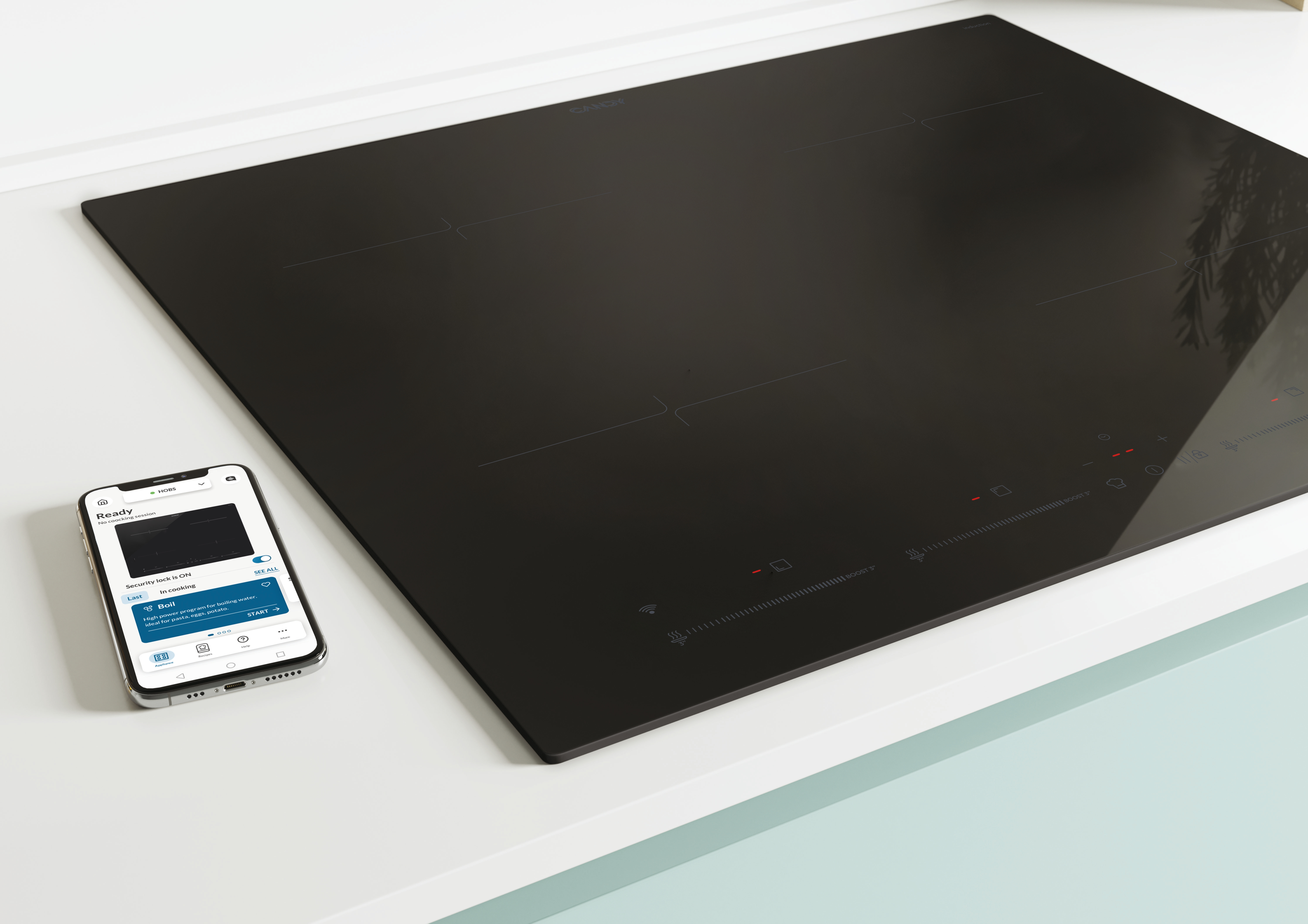Czarna płyta indukcyjna ze smartfonem. Biały blat i jasnoniebieska szafka.