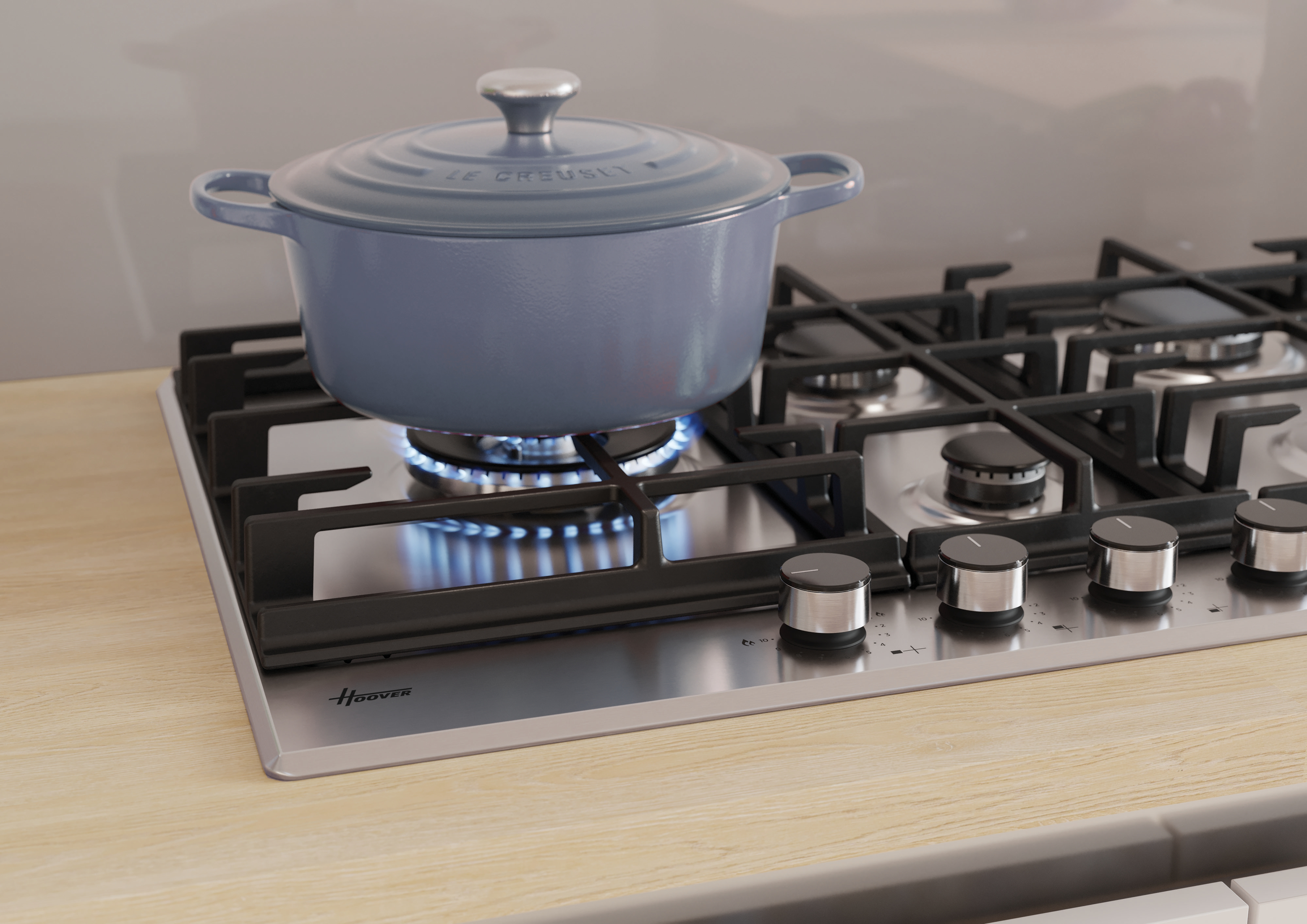 Piano cottura della cucina con una pentola blu Le Creuset sul fuoco, piano in legno e manopole.