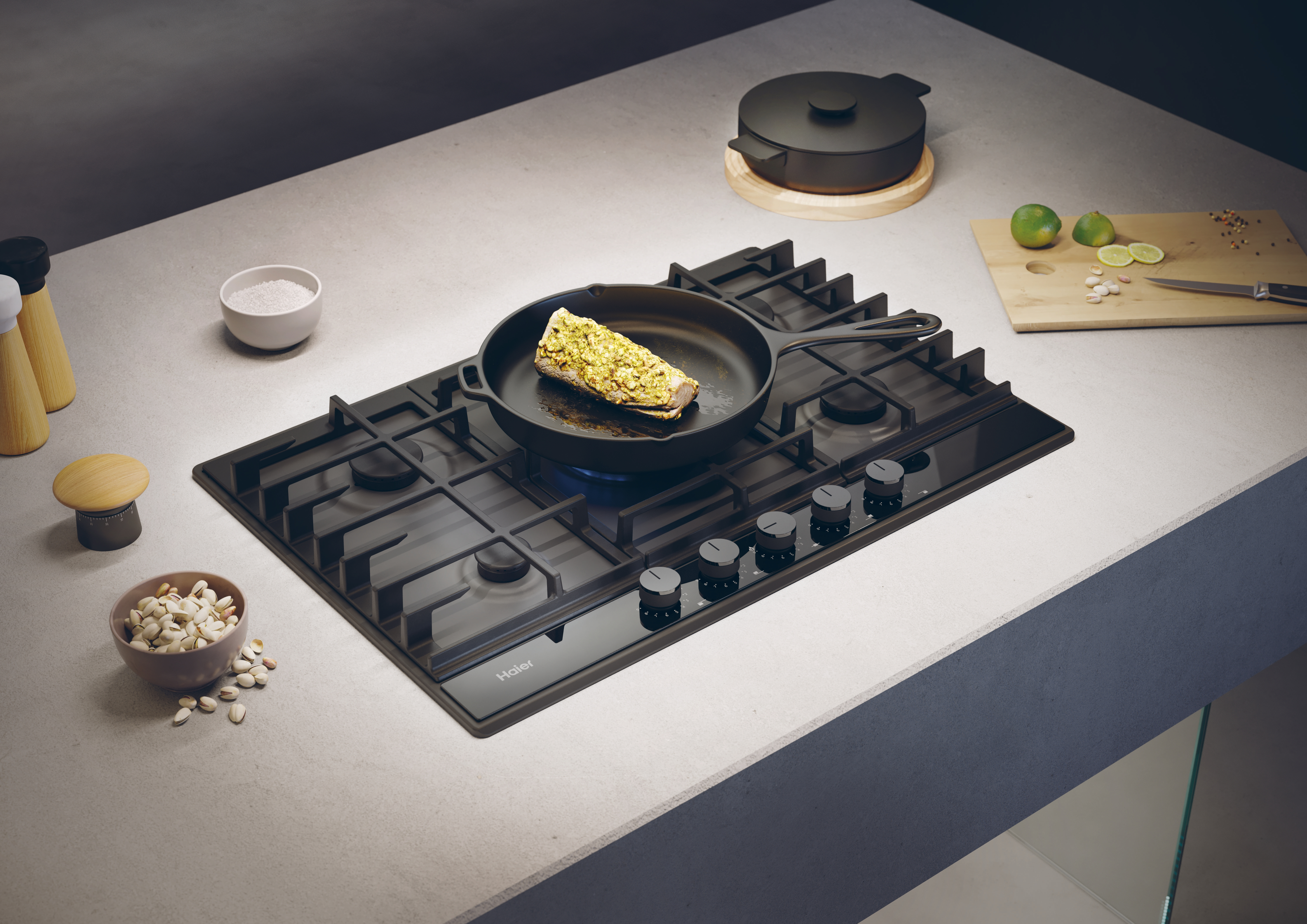 Escena de cocina con encimera de gas Haier, sartén y varios ingredientes de cocina.