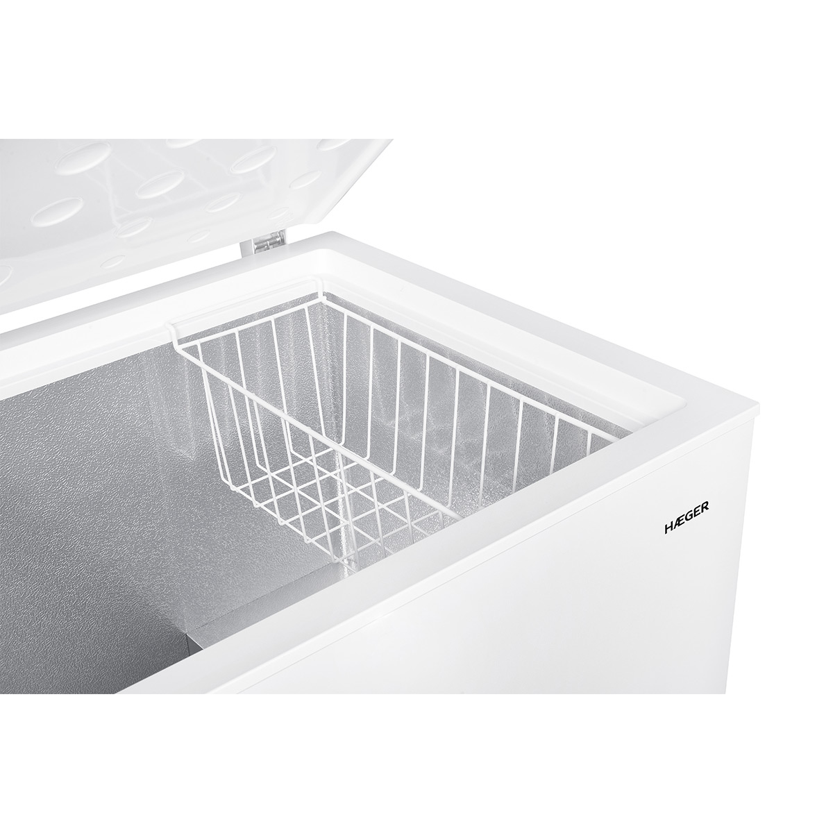 Biała zamrażarka skrzyniowa, otwarta, z drucianym koszem w środku. Wnętrze srebrne.