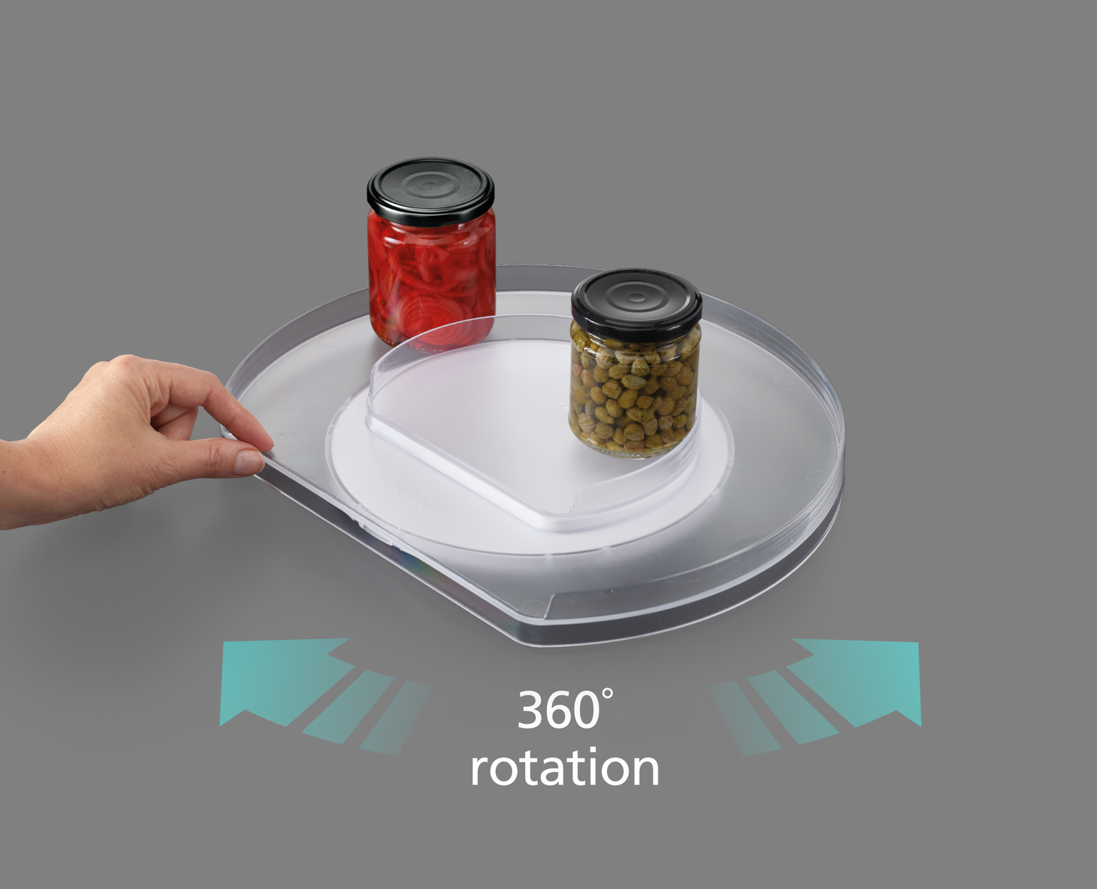 Obracany talerz z słoikami jedzenia. Ręka go obraca. Szare tło. Strzałki wskazują obrót 360°.
