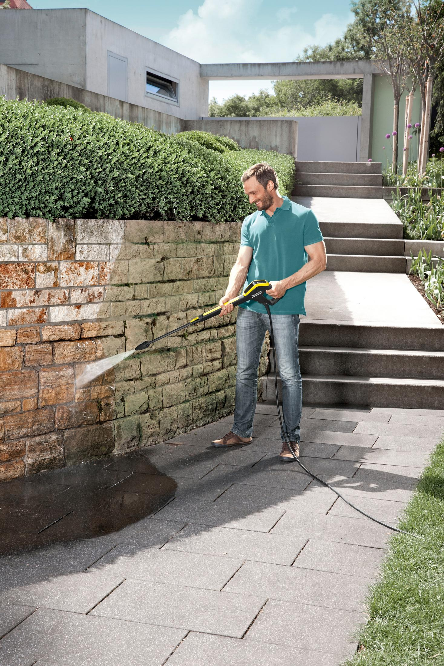 System nawadniania kropelkowego z różowym kwiatem i zieloną rośliną w tle.