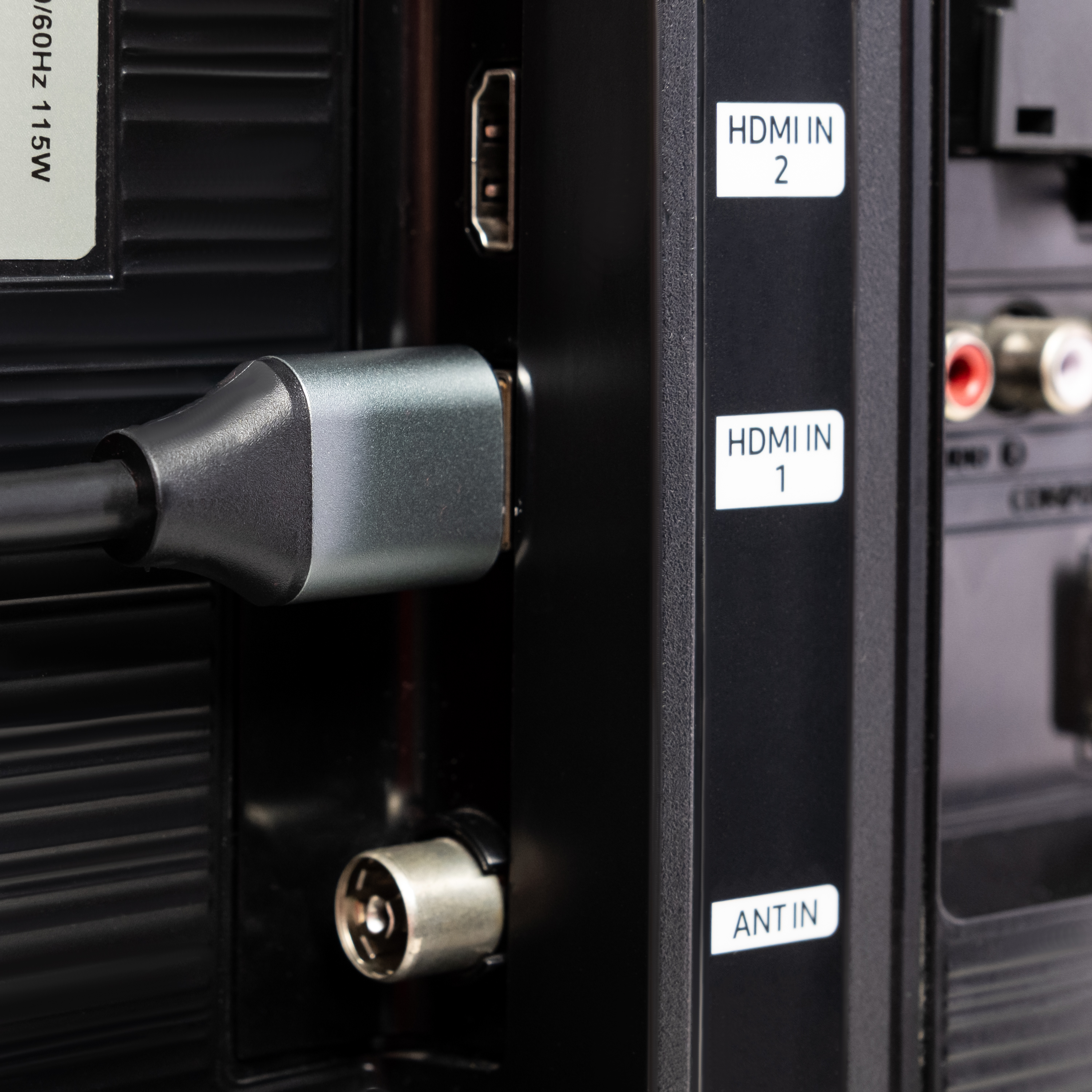 Kabel HDMI podłączony do telewizora, z widocznymi etykietami.