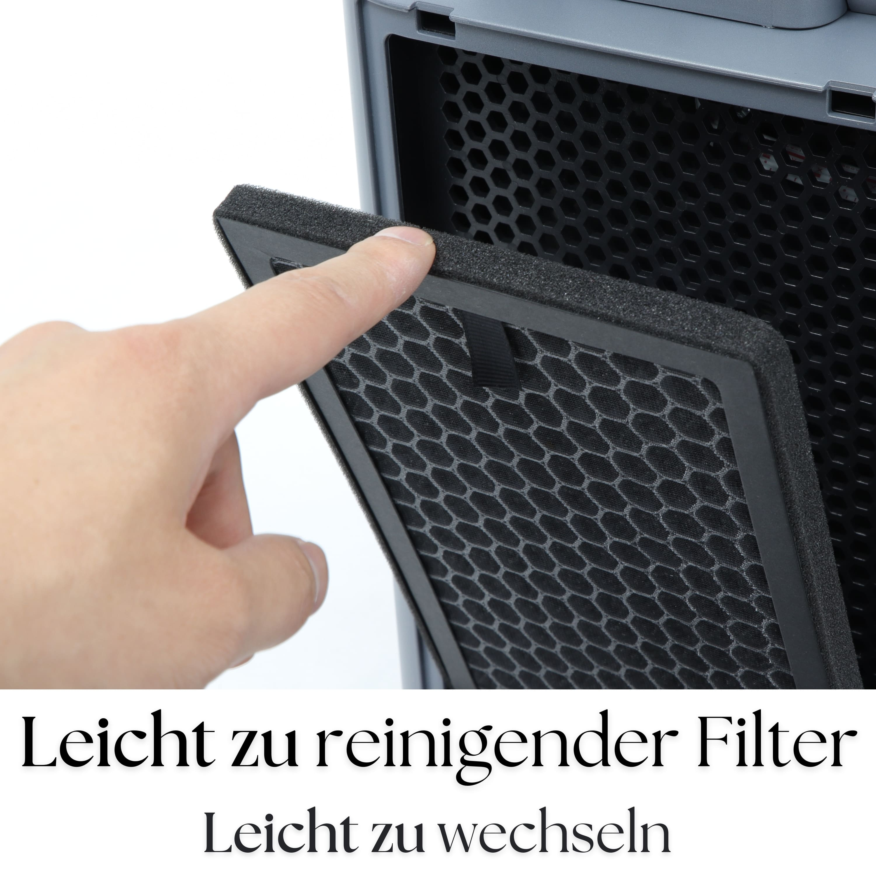 Ręka wyjmująca filtr z szarej oczyszczacza powietrza. Widoczny czarny filtr.