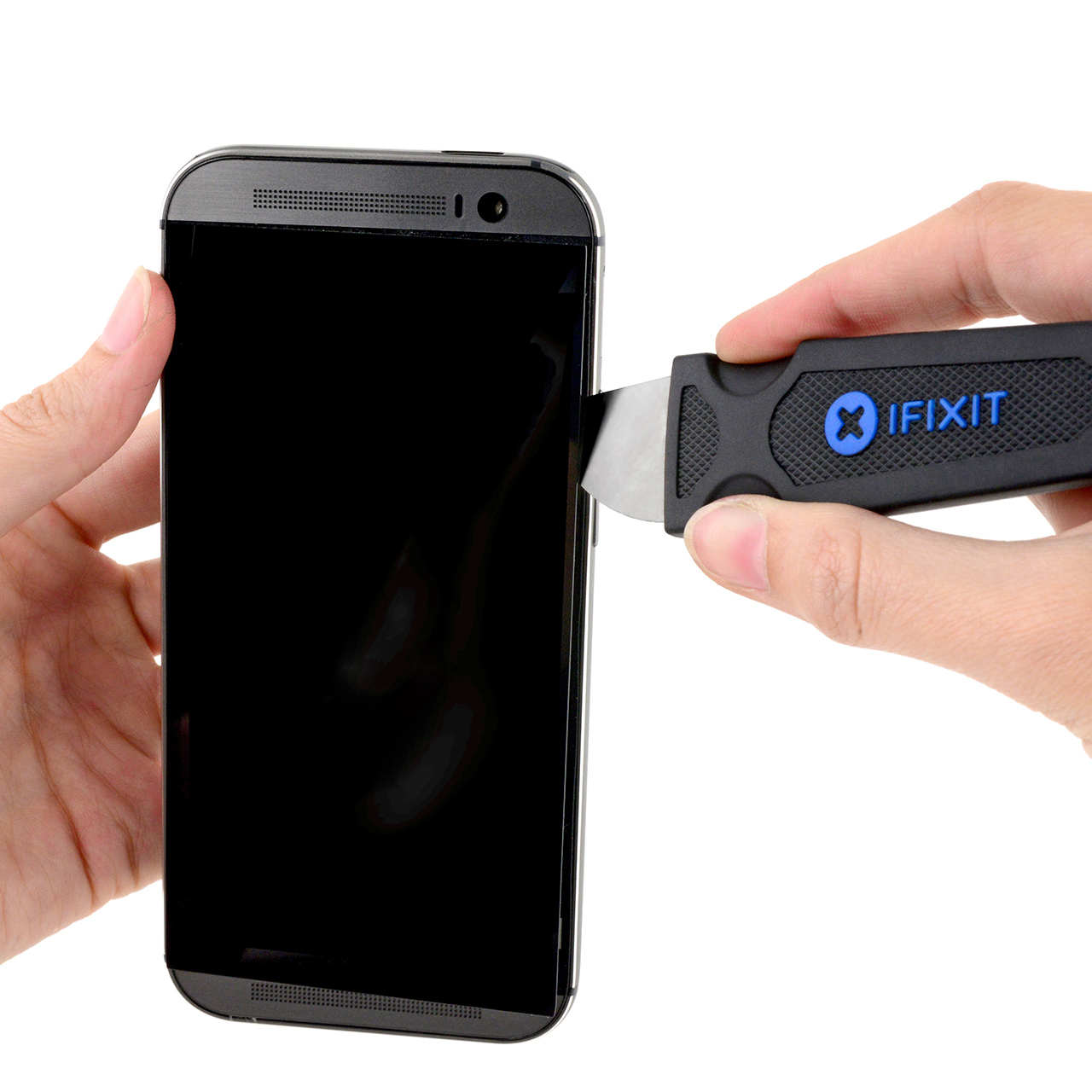 Eine Person öffnet mit einem iFixit-Messer ein schwarzes Smartphone auf weißem Grund.