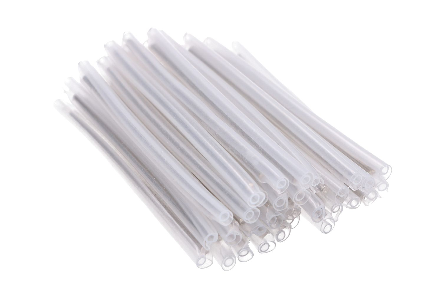 Stos przezroczystych, cienkich, cylindrycznych rurek na białym tle, widok diagonalny.