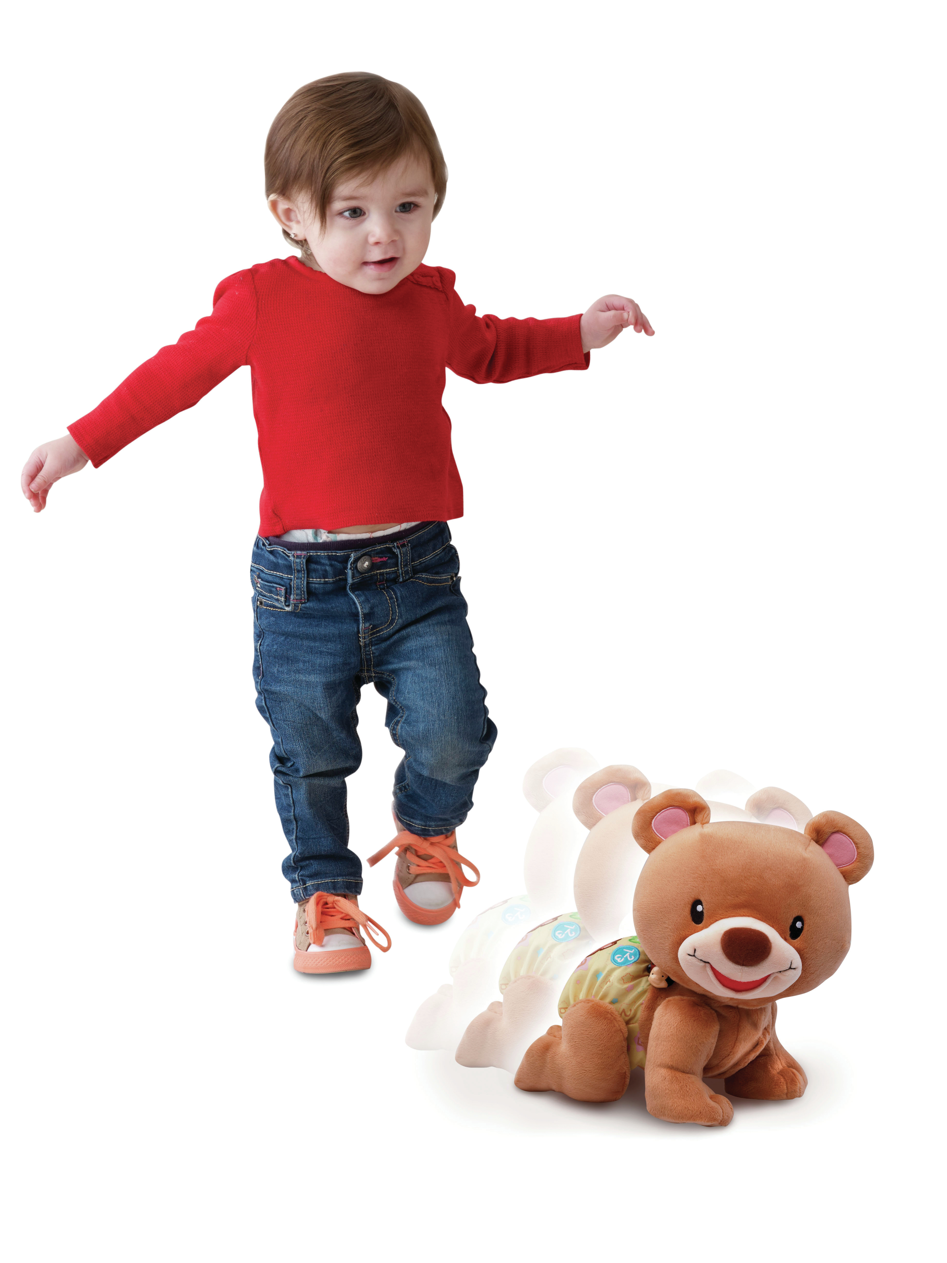 Un niño pequeño y un juguete de oso que gatea. El niño camina hacia el juguete.