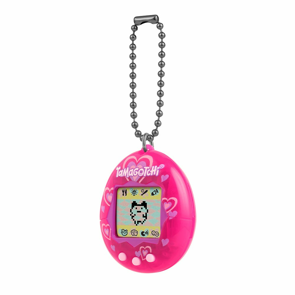 Różowa zabawka Tamagotchi z łańcuchem. Ekran pokazuje pikselowego zwierzaka. Serca zdobią ramkę.