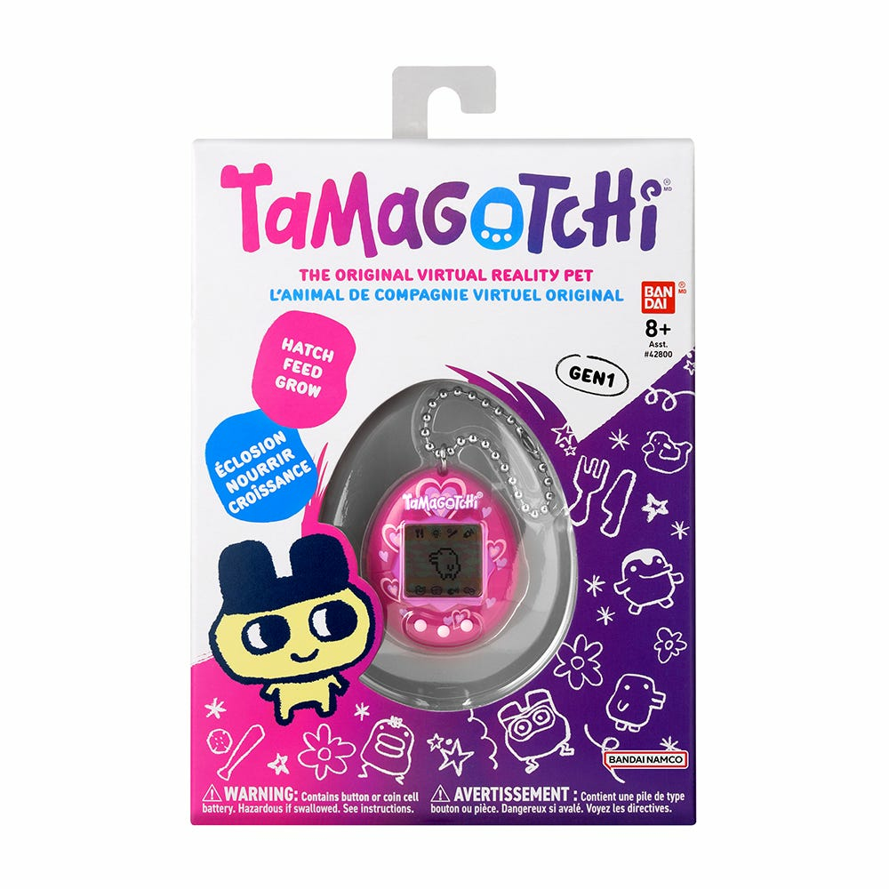 Pudełko z zabawką Tamagotchi. Pudełko jest różowe i fioletowe ze zdjęciem zwierzaka i marką.