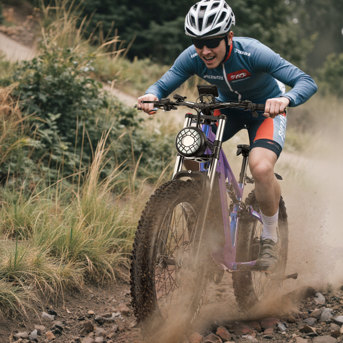Mężczyzna jadący fioletowym rowerem elektrycznym po polnej ścieżce. W kasku i okularach.