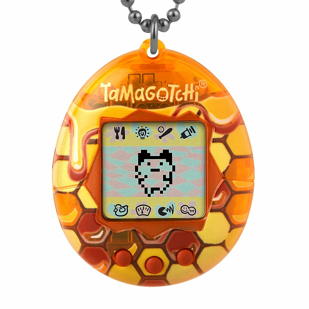 Urządzenie wirtualnego zwierzaka Tamagotchi w wzorze plastra miodu, pokazujące ekran zwierzaka.
