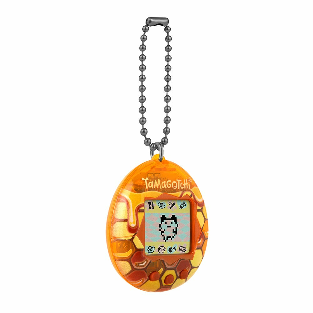 Urządzenie wirtualnego zwierzaka Tamagotchi w wzorze plastra miodu, pokazujące ekran zwierzaka.
