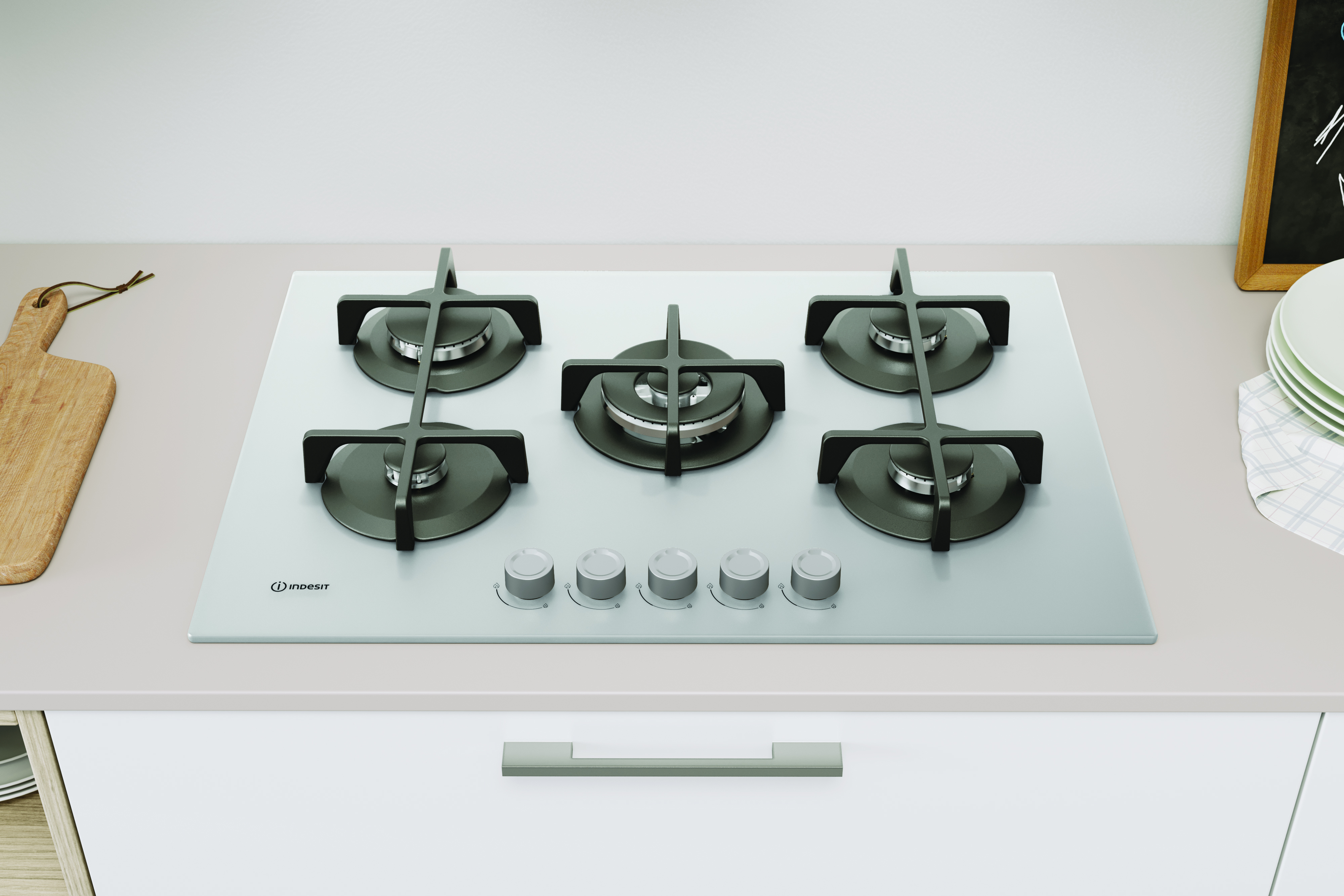 Srebrna płyta grzejna z 5 palnikami znajduje się na białym blacie.