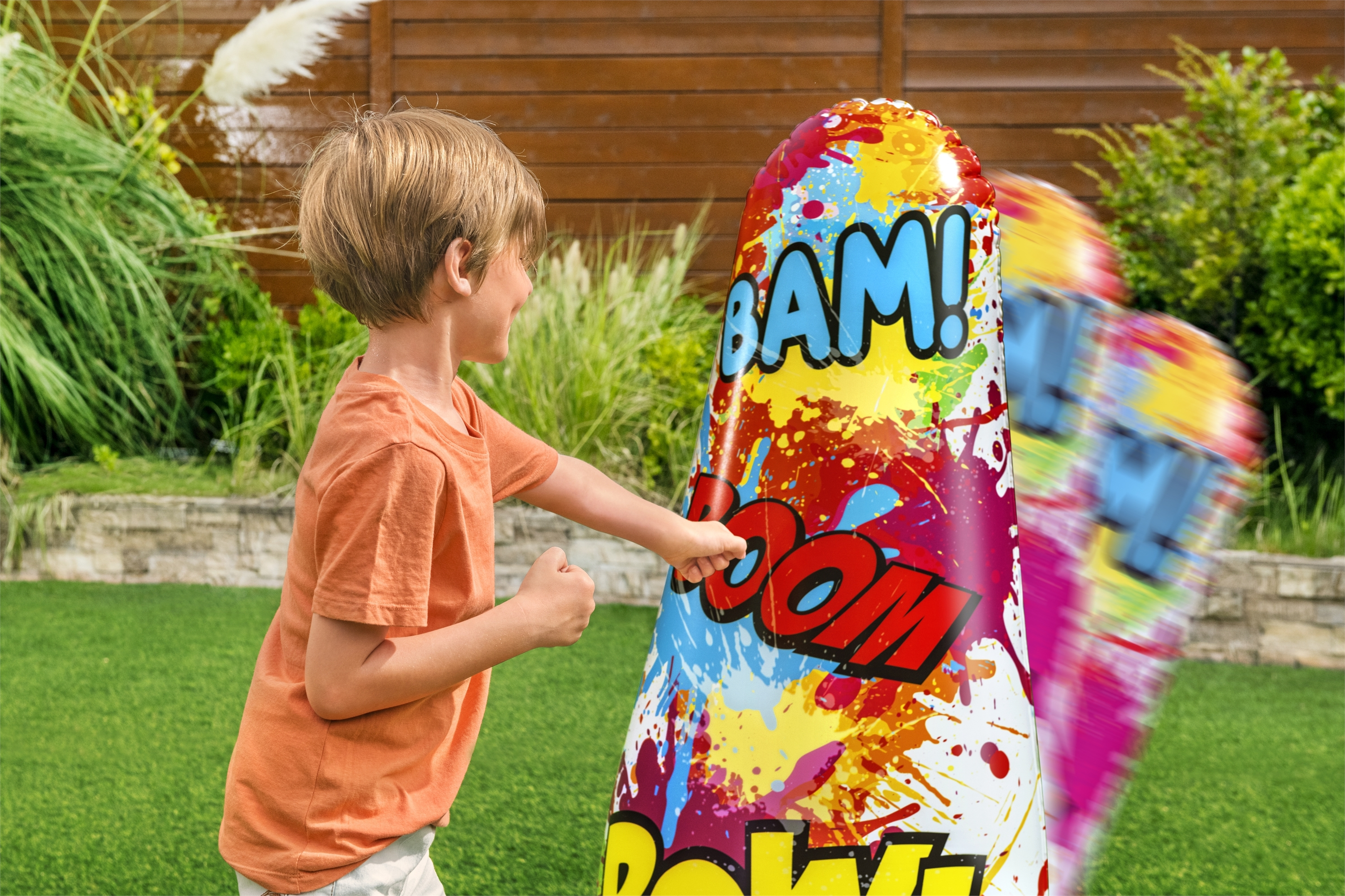 Un niño golpea un juguete inflable con la palabra 'BAM!' escrita.