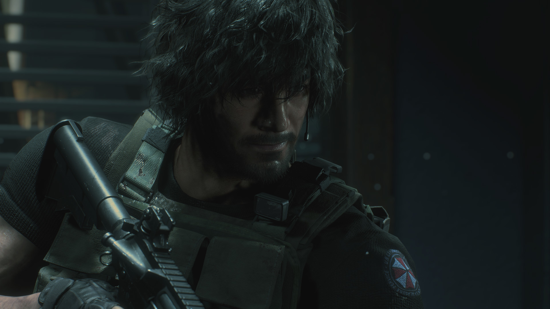 Un uomo in tenuta tattica tiene un'arma, guardando in basso. Il logo di Resident Evil sulla manica.