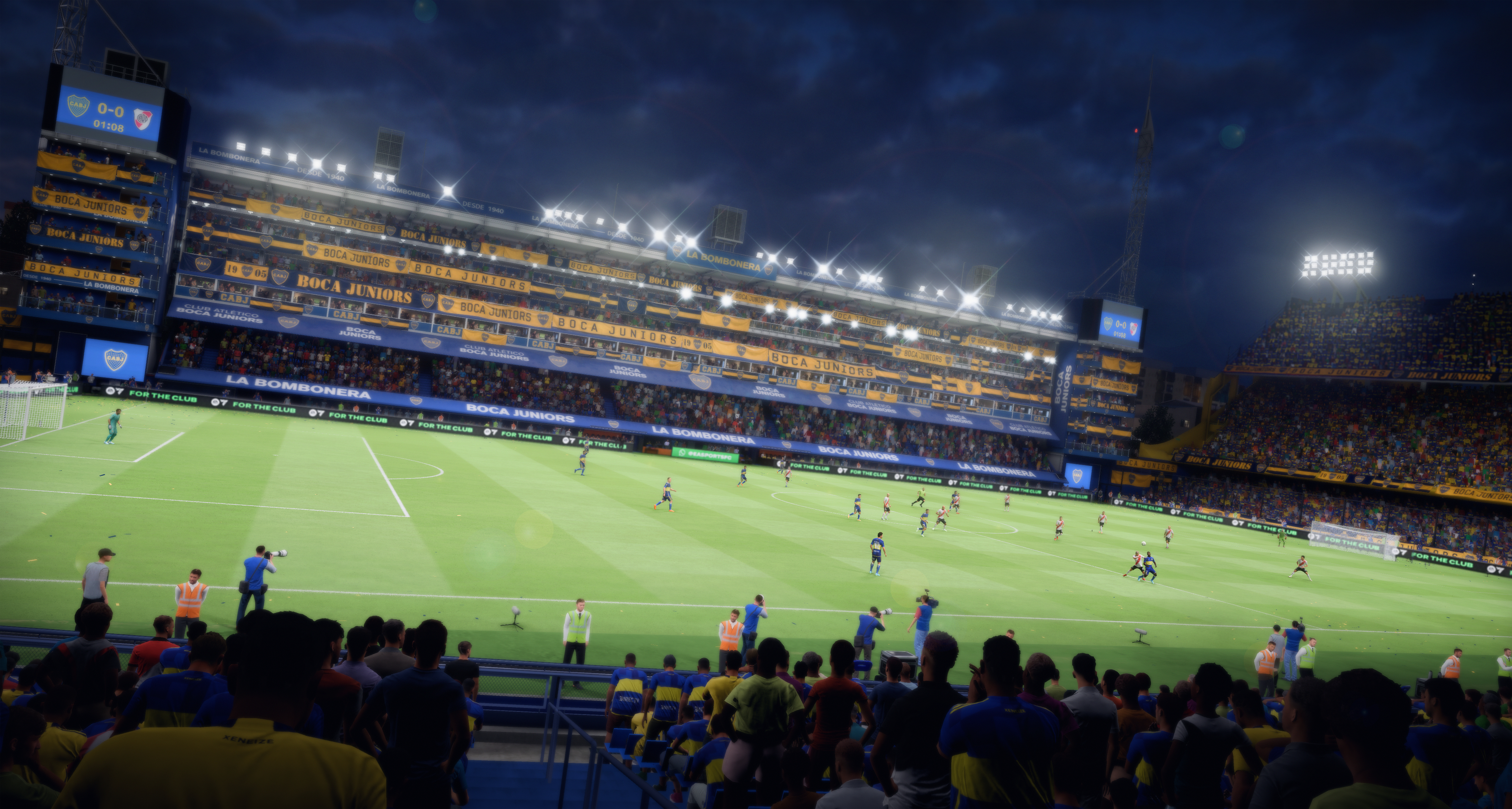 Stadio di calcio notturno con giocatori in campo; Boca Juniors vs River Plate.
