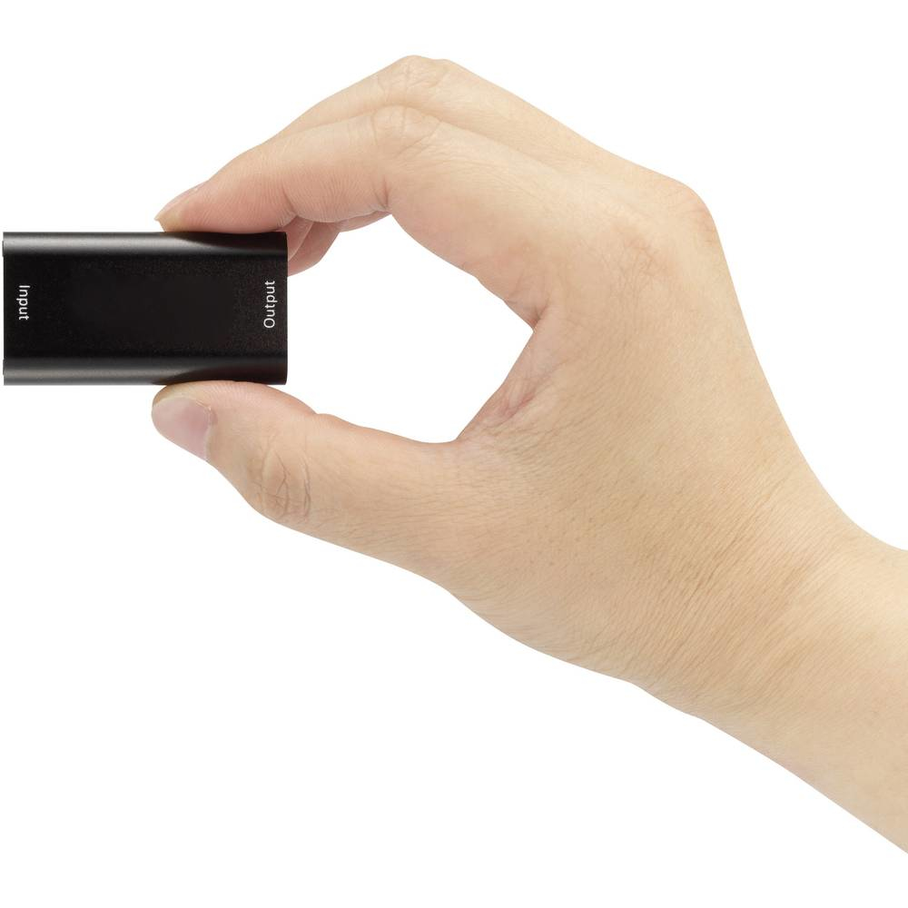 Mano che tiene un dispositivo HDMI nero con etichette di ingresso e uscita.