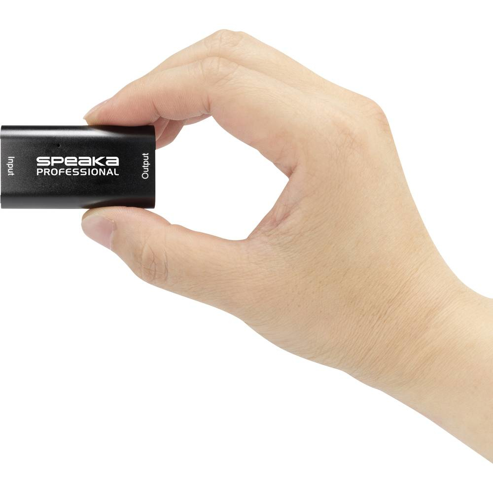 Mano che tiene un adattatore HDMI Speaka Professional nero, etichettato con ingresso e uscita.