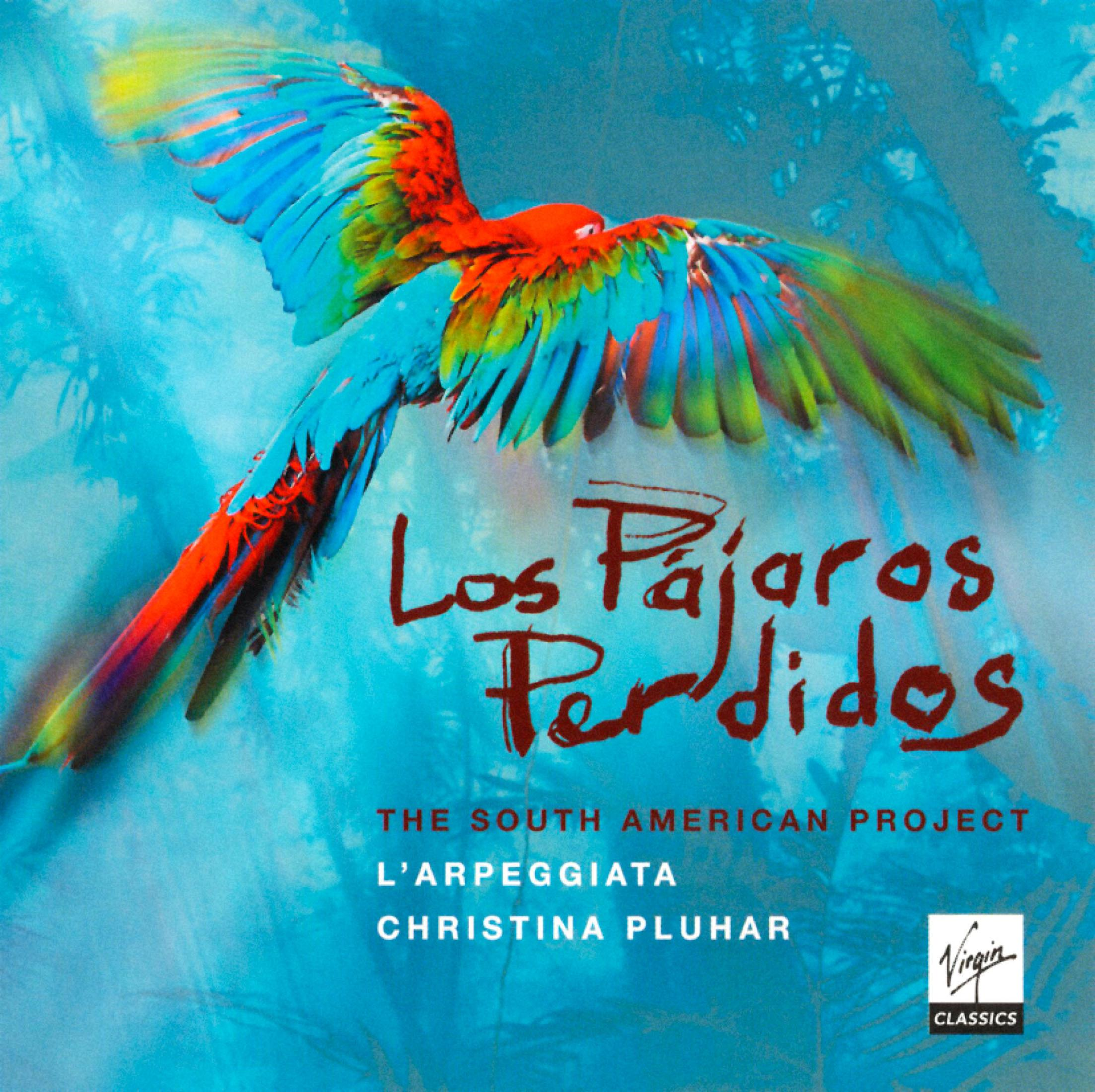 Papagei mit bunten Flügeln, betitelt 'Los Pajaros Perdidos'. Hintergrund ist ein blauer Himmel.
