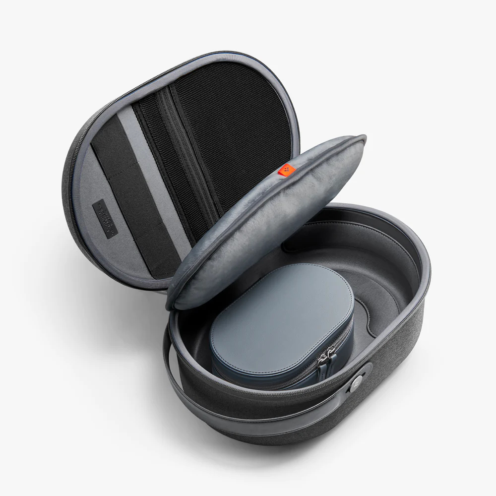 Szara otwarta walizka ze słuchawkami i małym etui w środku.