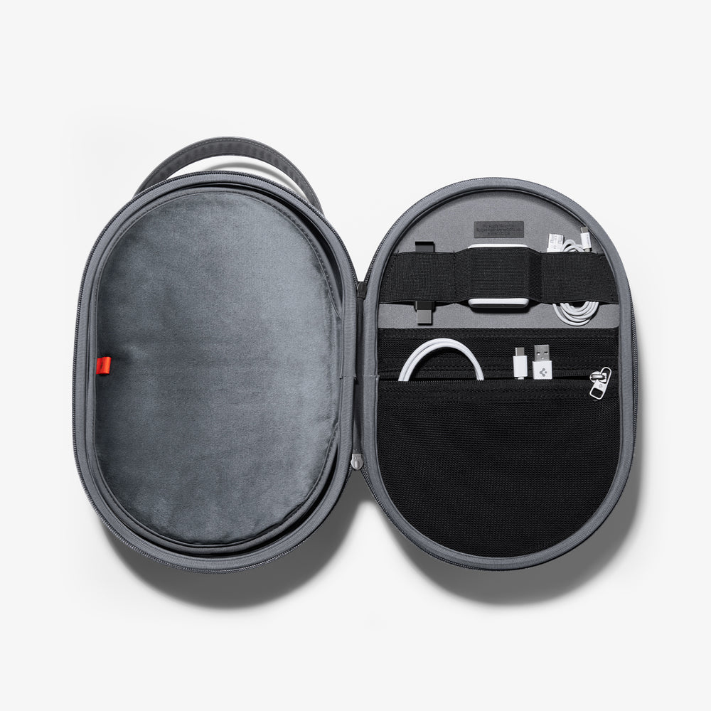 Otwarta szara walizka podróżna z przegródkami i różnymi akcesoriami technologicznymi w środku.