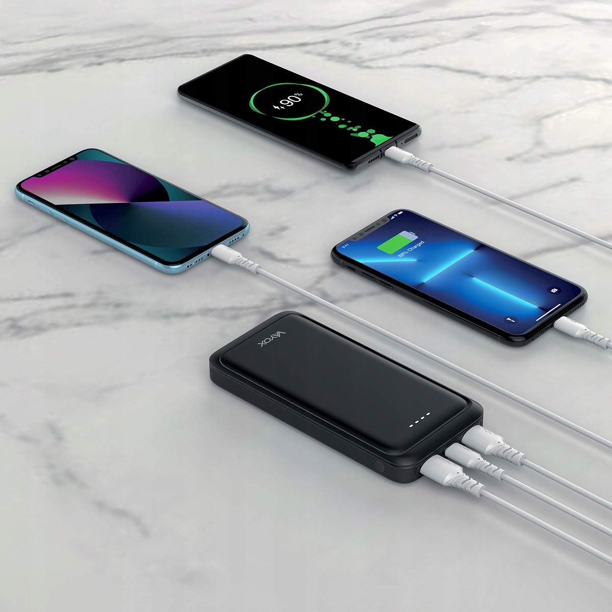 Trzy telefony ładujące się z czarnego power banku. Jeden telefon pokazuje 90% naładowania.