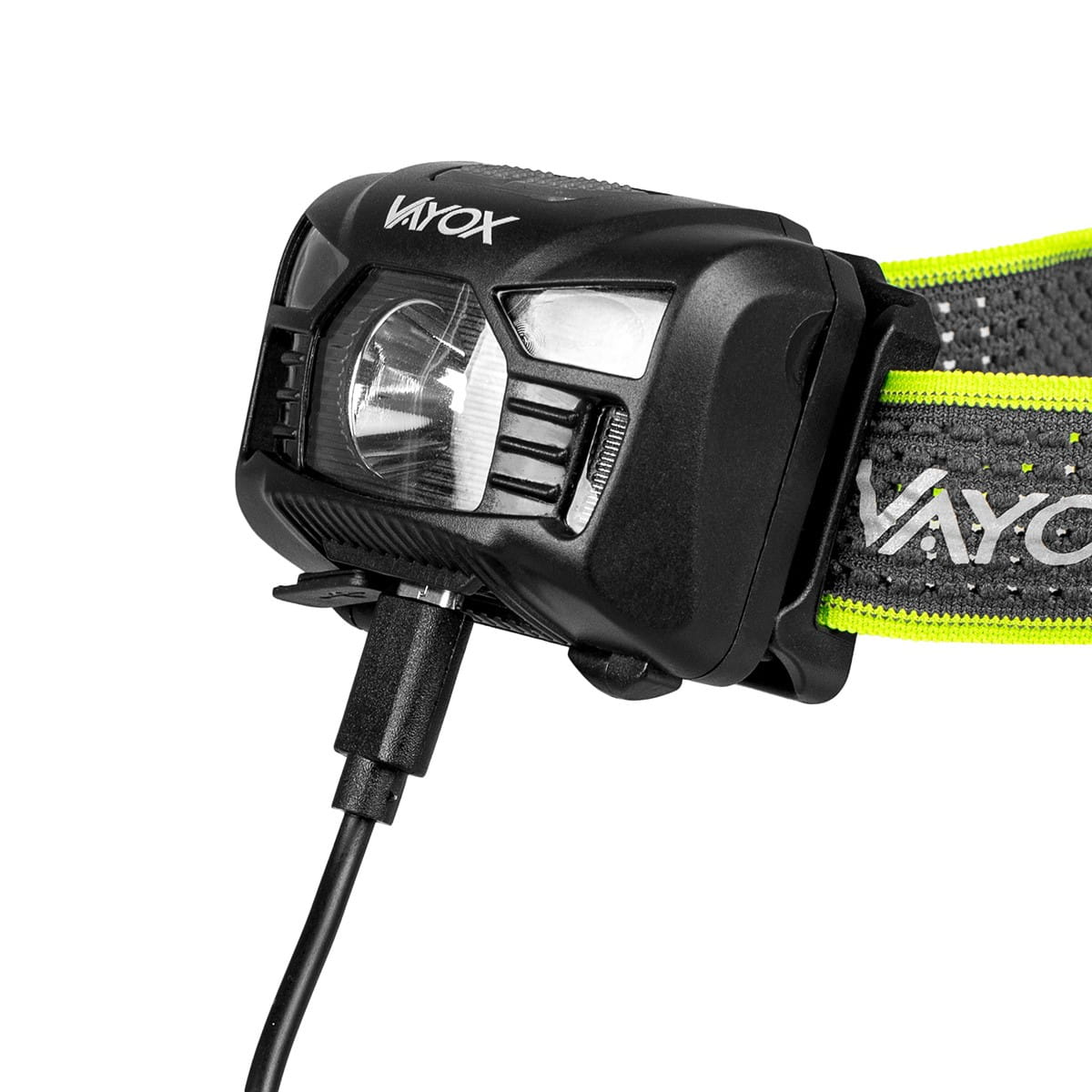 Ładowanie czołówki. Zbliżenie na czołówkę z podłączonym kablem do ładowania. Widoczna opaska i ładowarka.