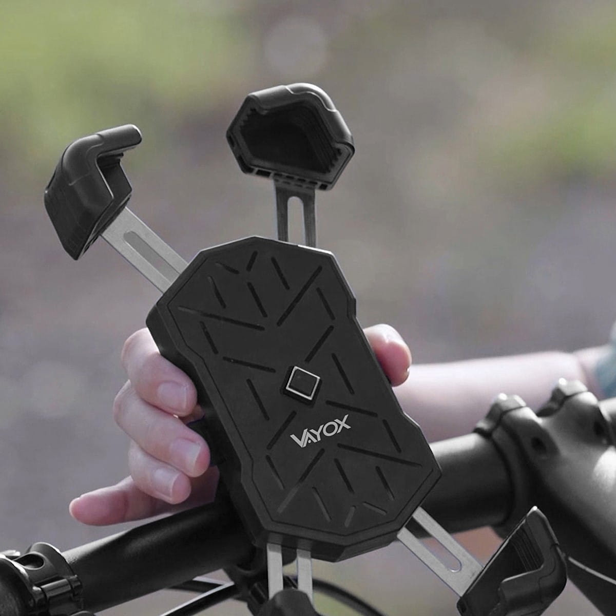 Czarny uchwyt na telefon do roweru z ręką. Jest przymocowany do kierownicy roweru.