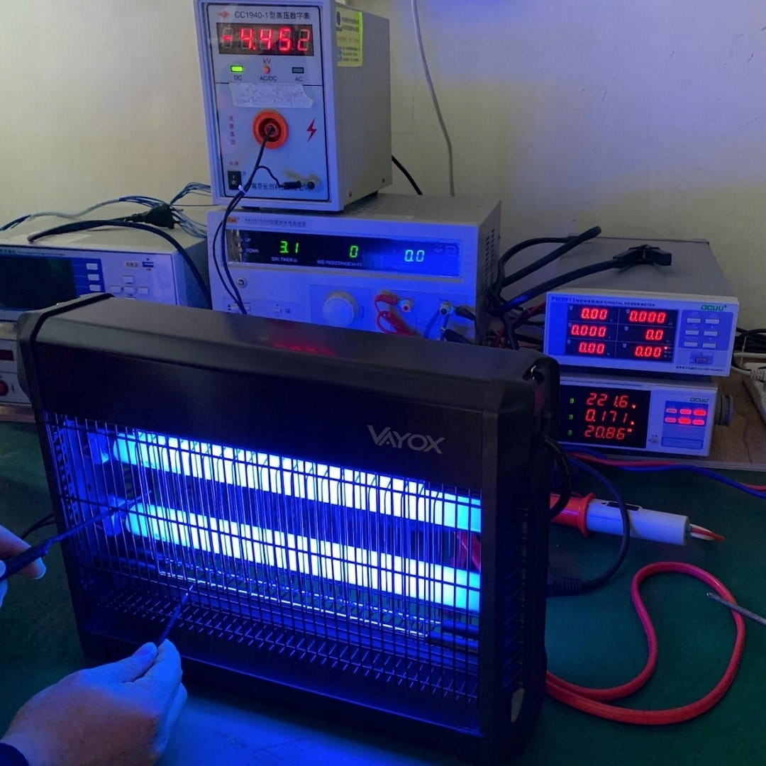 Zabójca owadów z niebieskimi światłami. Różne urządzenia elektroniczne znajdują się w tle.