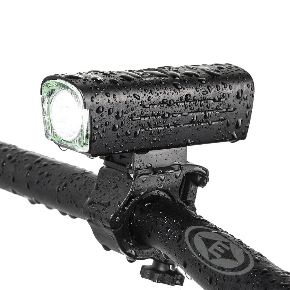 Czarne światło rowerowe zamontowane na kierownicy roweru, mokre od kropli wody. Białe tło.