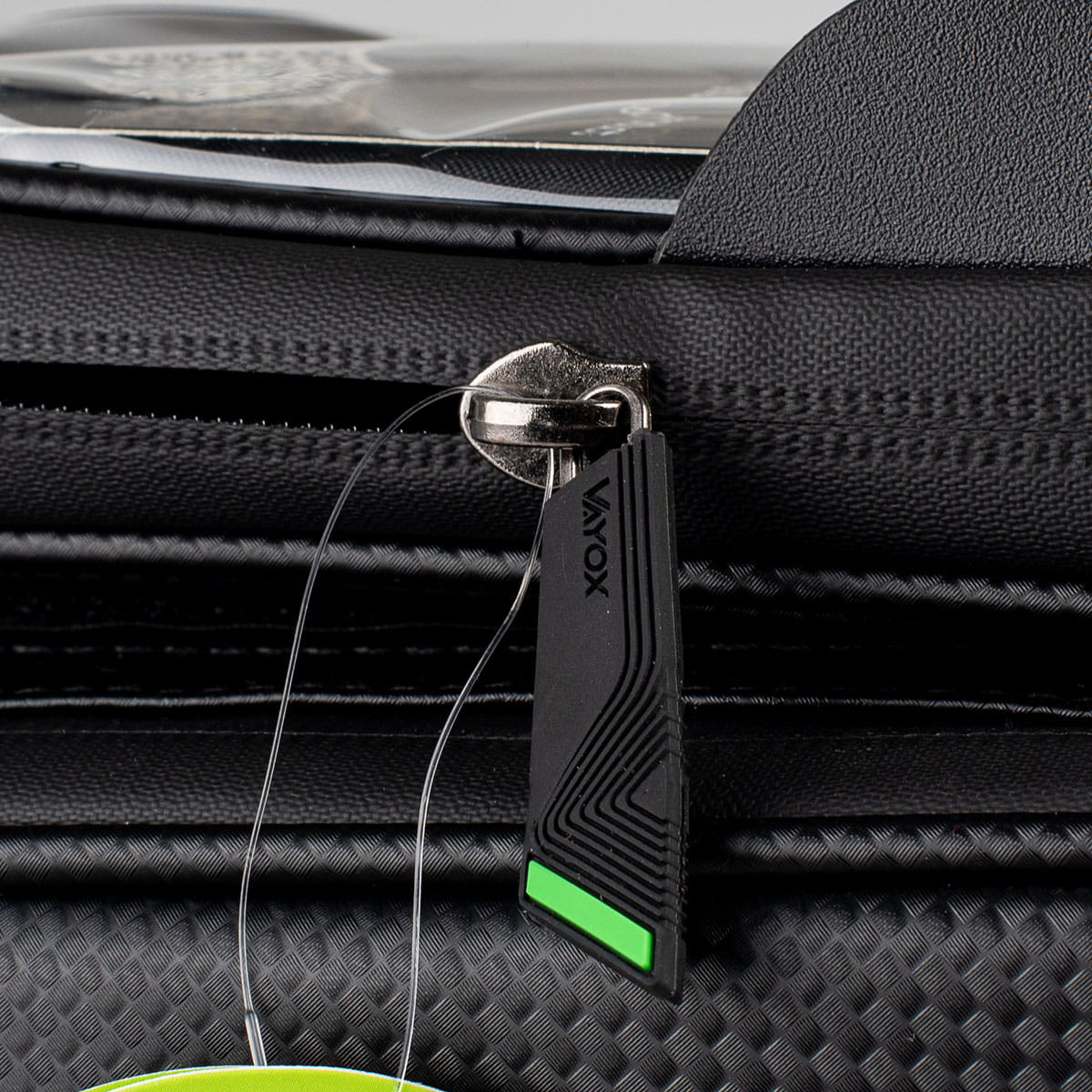 Zbliżenie na suwak czarnej torby rowerowej z logo VAYOX i zielonym akcentem.