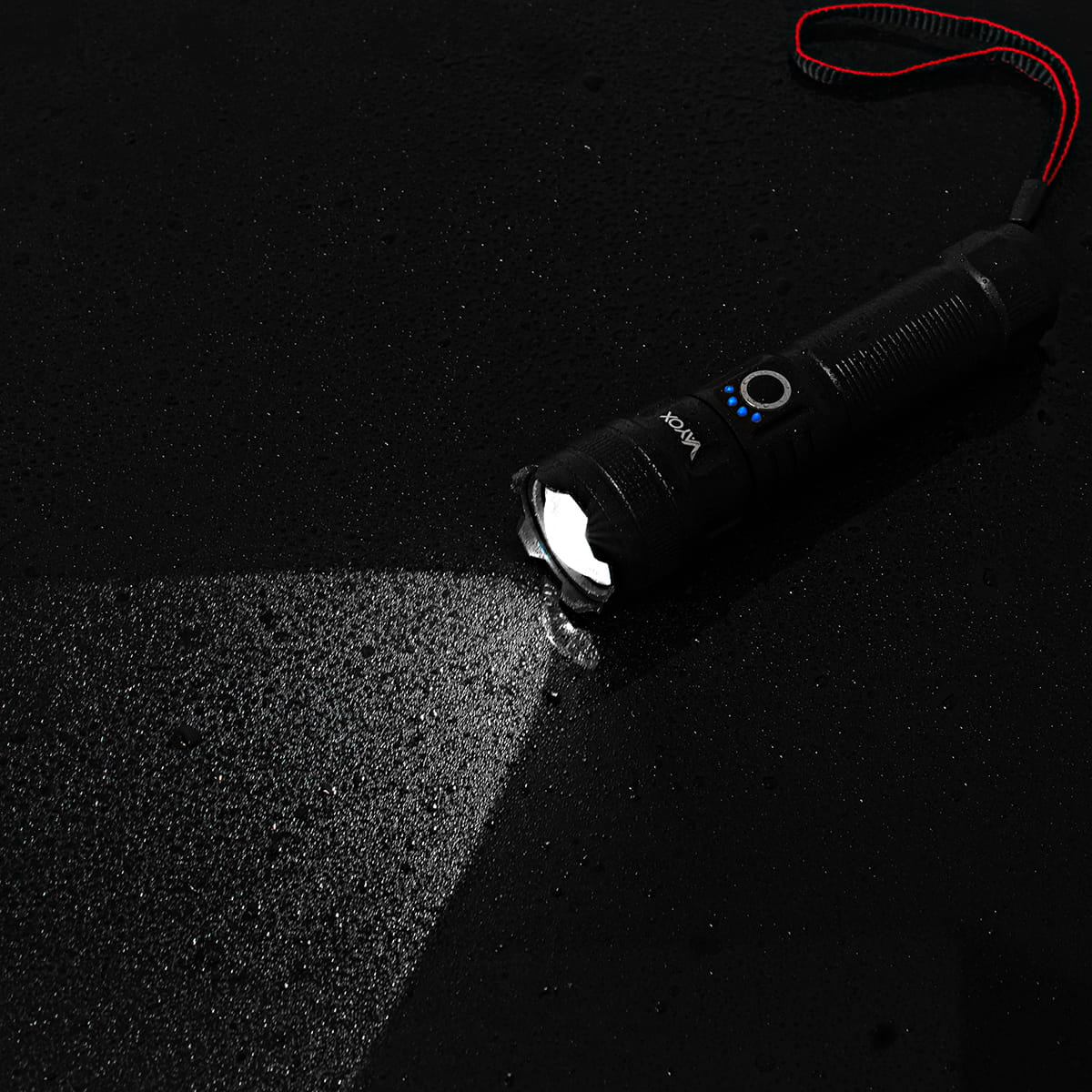 Czarna latarka na ciemnej powierzchni, emitująca wiązkę światła.