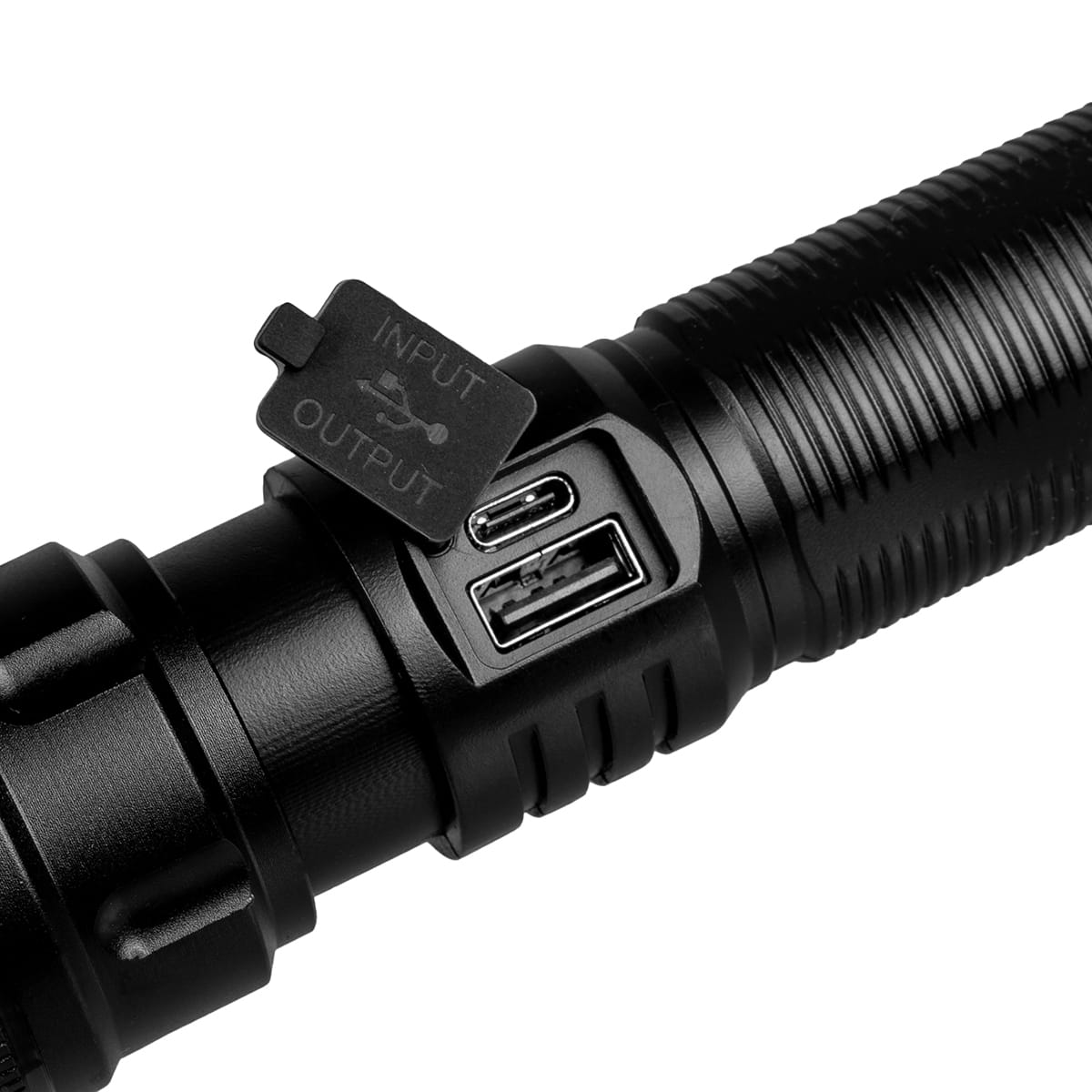 Zbliżenie czarnej latarki z widocznymi portami wejściowymi i wyjściowymi.