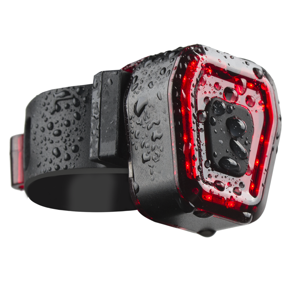 Czarne tylne światło rowerowe z czerwonymi światłami, pokryte kroplami wody. Czarny pasek widoczny po lewej stronie.