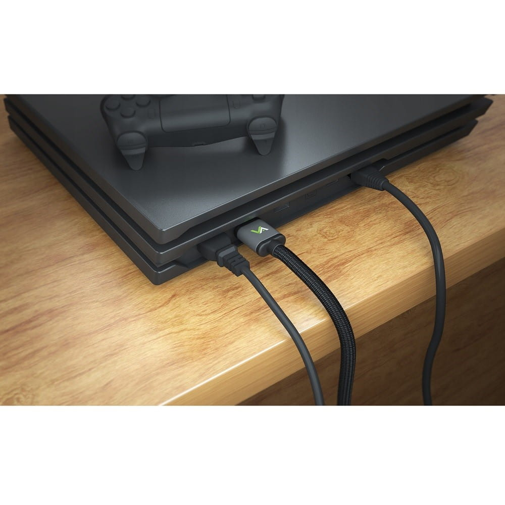 Czarna konsola do gier z podłączonymi kablami, na drewnianej powierzchni.