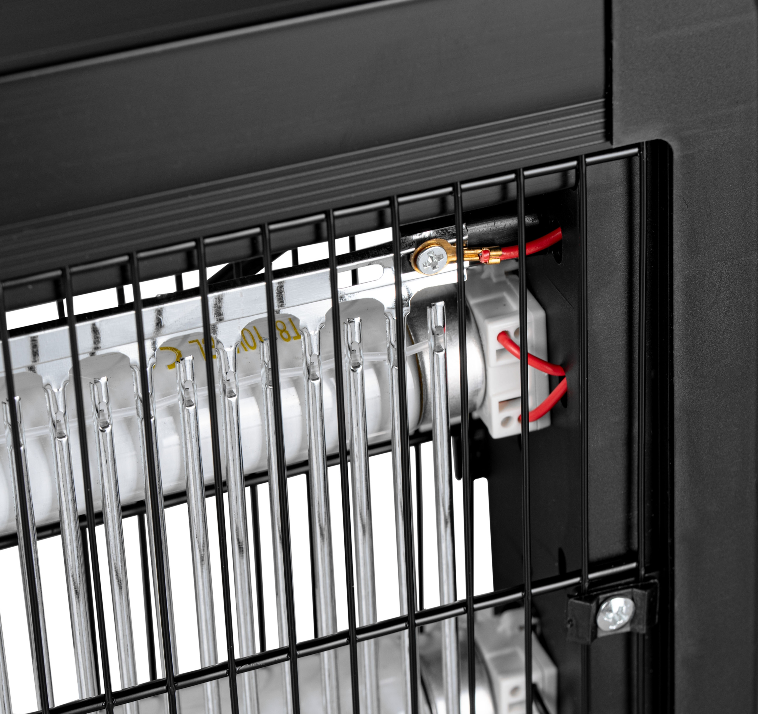 Zbliżenie na elementy grzewcze grzejnika z kratką ochronną.