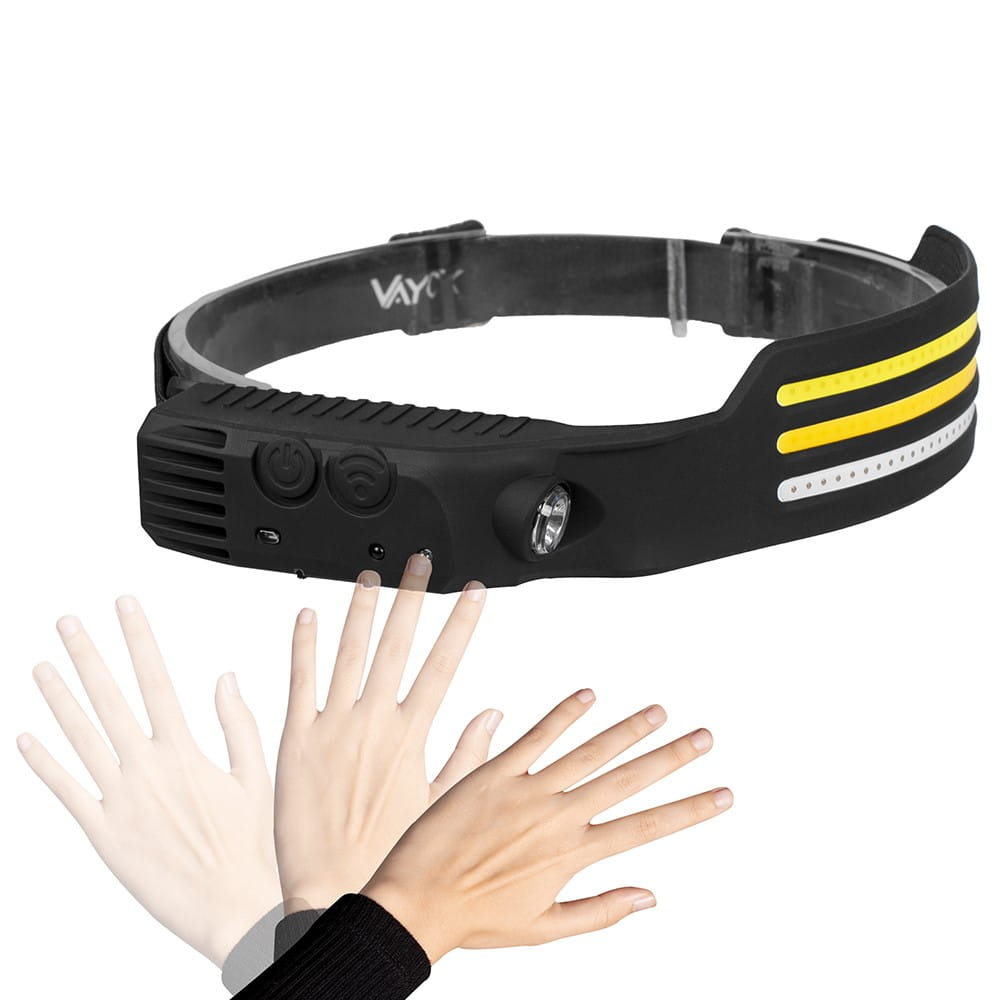 Czarna latarka czołowa z żółtymi paskami. Dłonie gestykulują w jej kierunku.