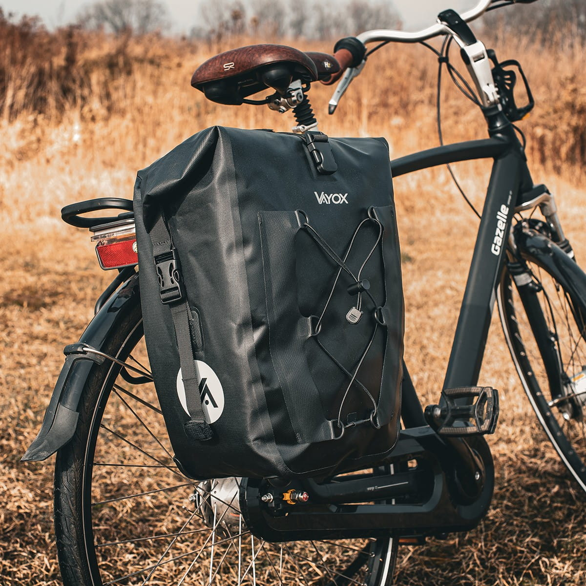 Czarna torba rowerowa przymocowana do czarnego roweru. Torba jest na tylnym bagażniku.