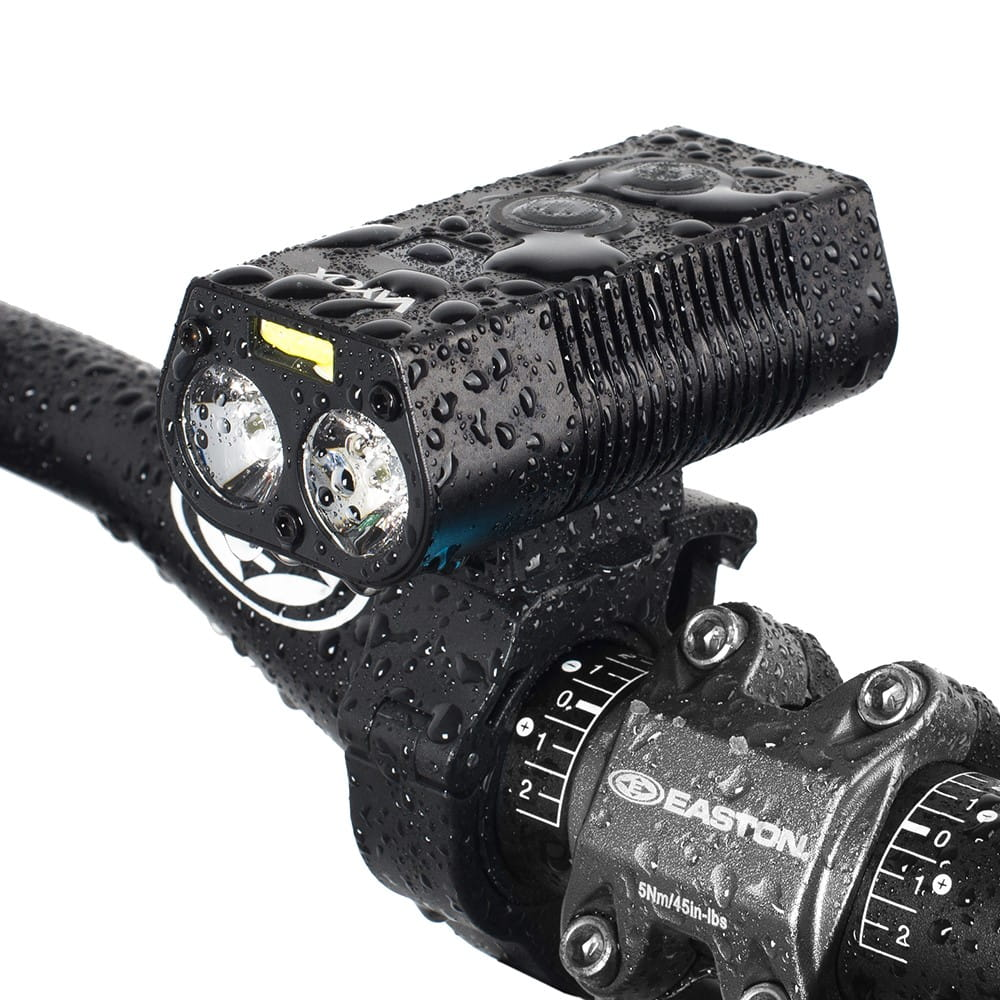 Czarna lampa rowerowa zamontowana na kierownicy. Ma dwa światła.