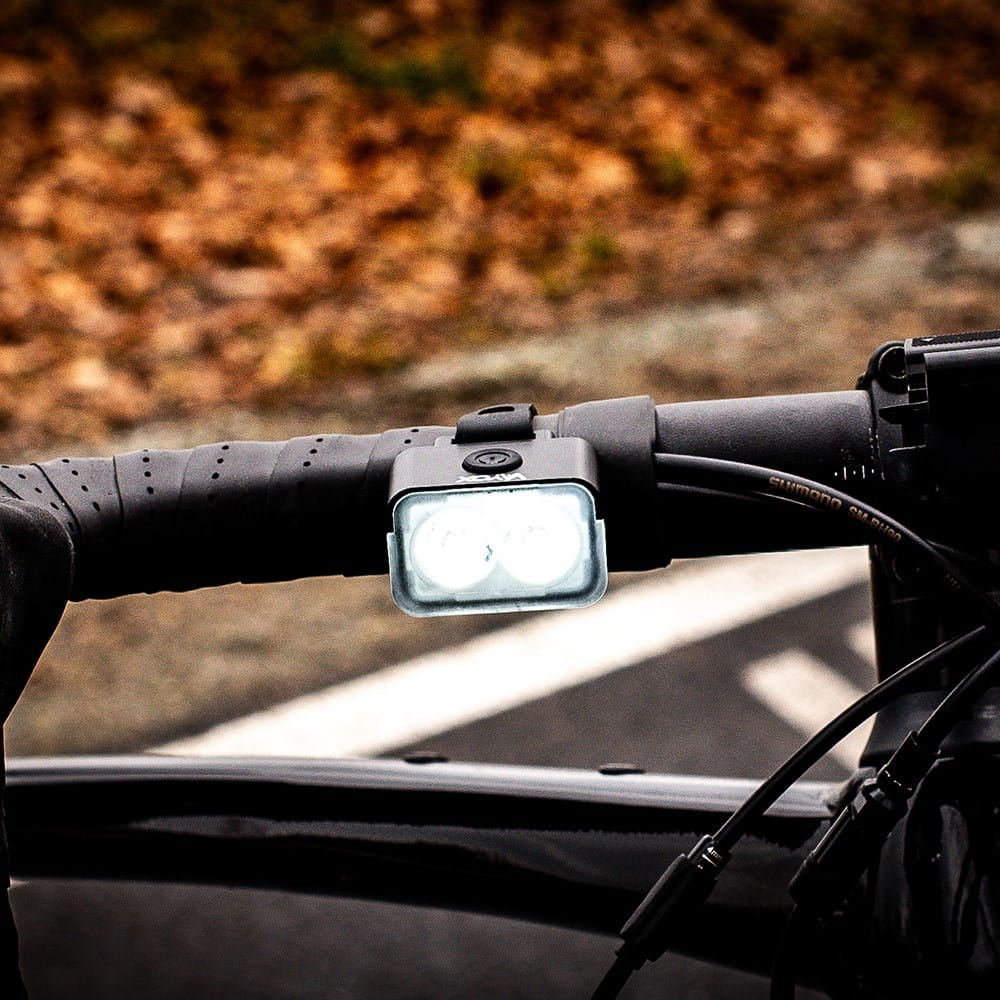 Dłonie otwierające czarną torbę z pomarańczowymi detalami, ujawniając wewnętrzne przegrody.